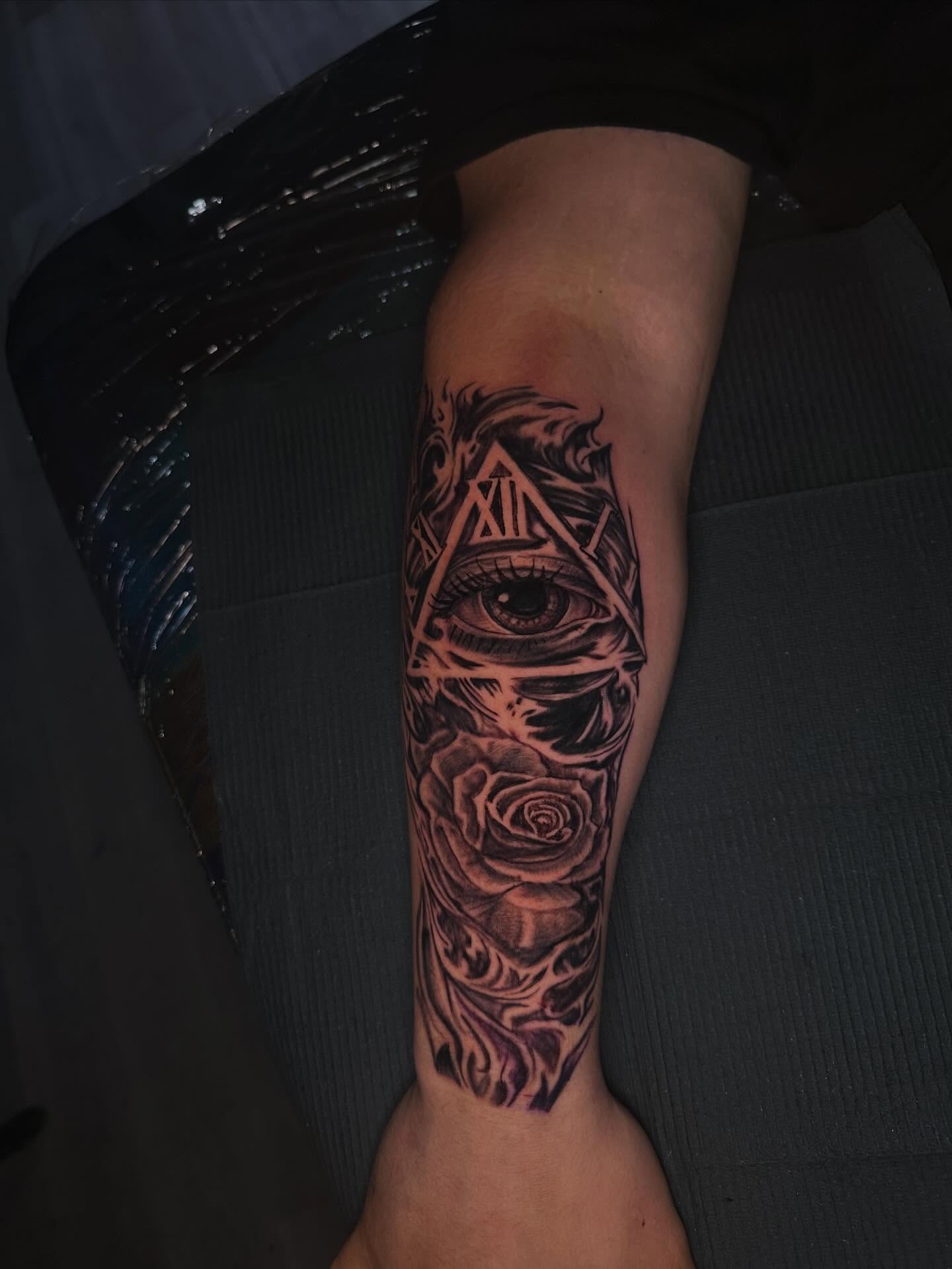 Eye and rose realism tattoo on the calf by Aj Negrete Jr.