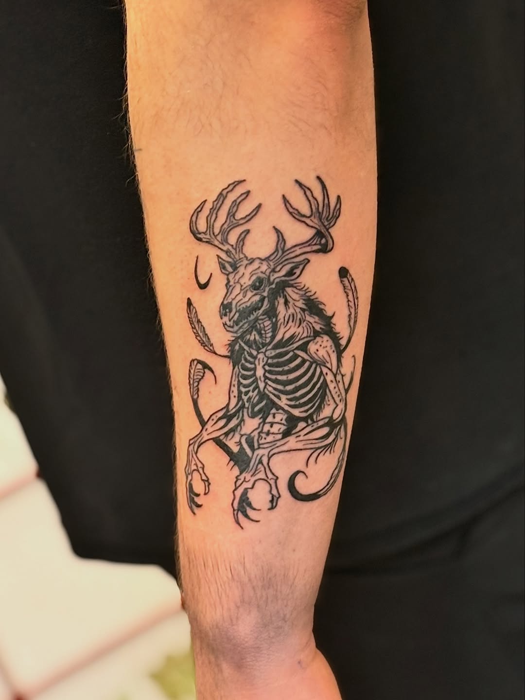 Creature and deer antlers dark art tattoo on the forearm by CJ