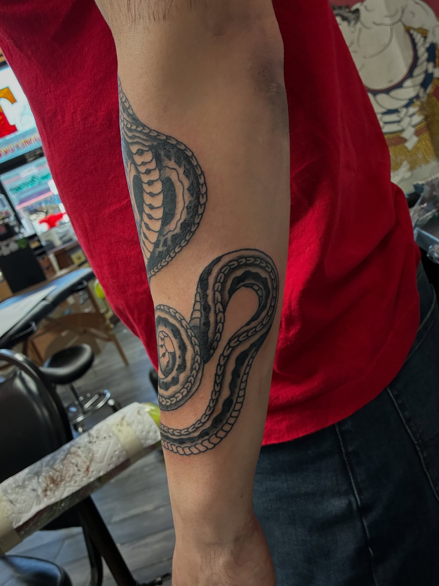 Snake black and grey tattoo on the forearm by Kennedy Cole