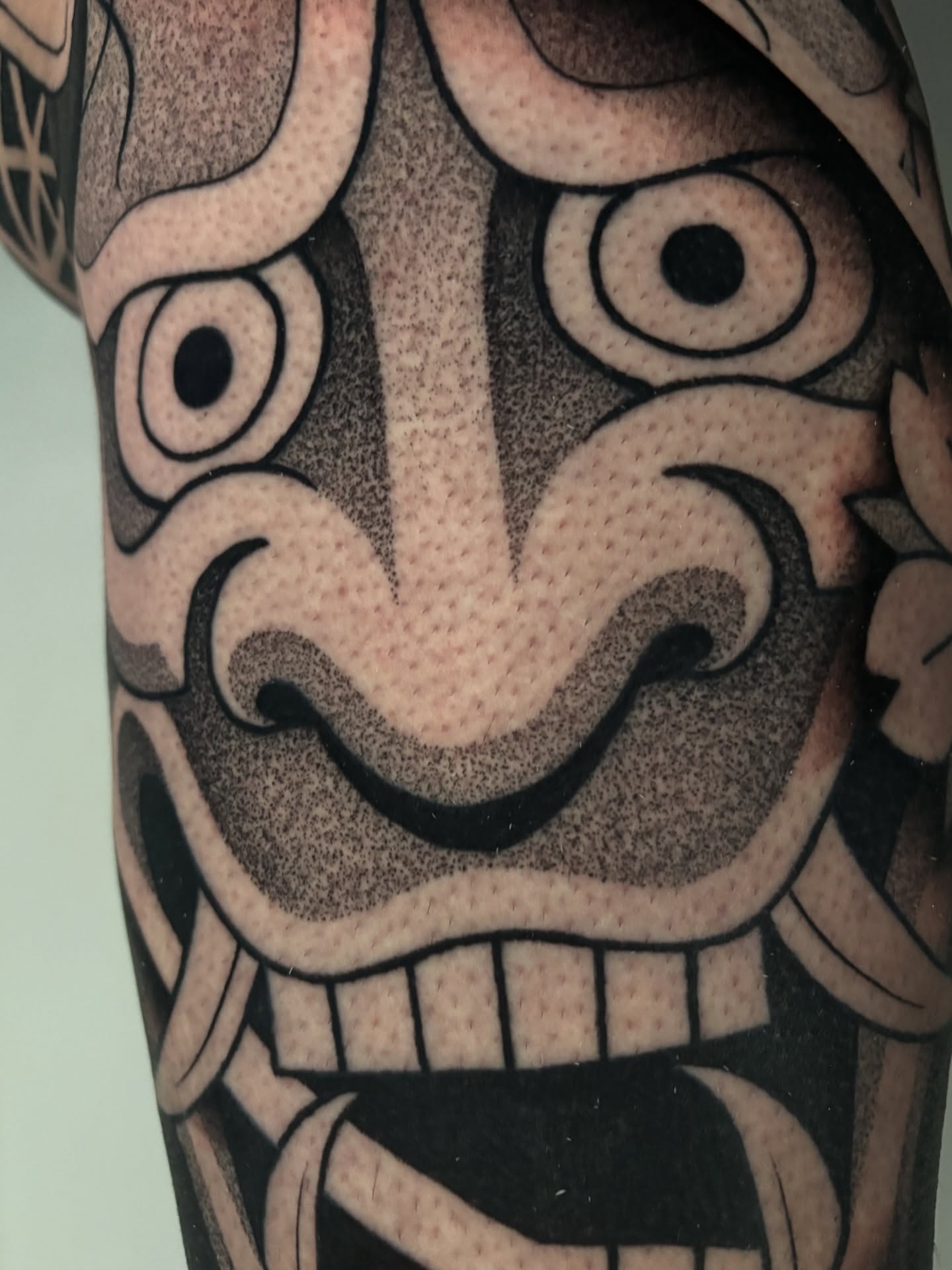 Mask dotwork tattoo on the forearm by Mitch Koch