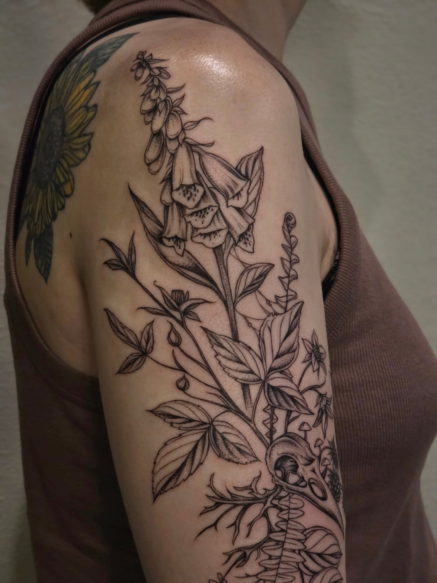 Foxglove plant black and grey tattoo on the upper arm by Sierra (cc) Klein