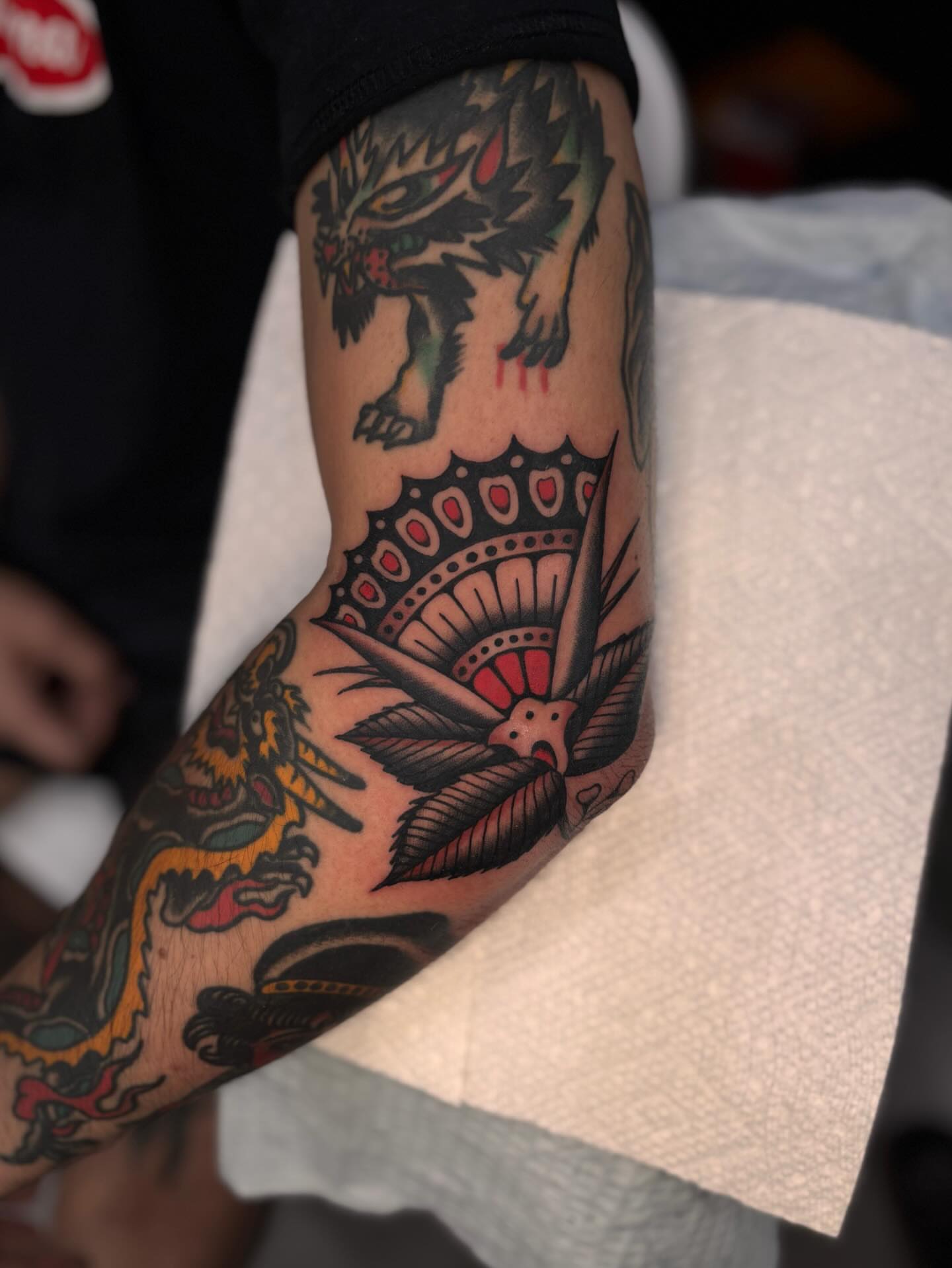 Wolf and bird American traditional tattoo on the forearm by Jesse Smith, Chicago, Illinois