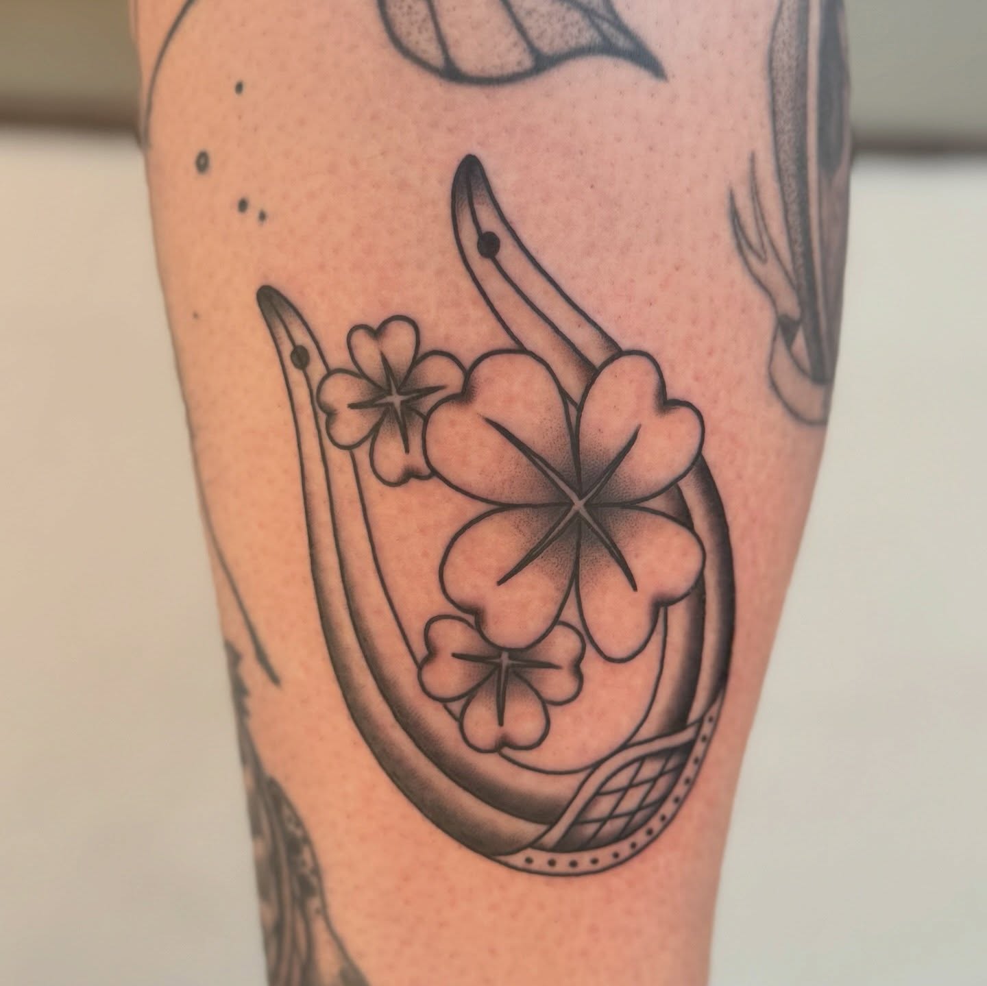 Plumeria flowers black and grey tattoo on the forearm by Maddie Hammell