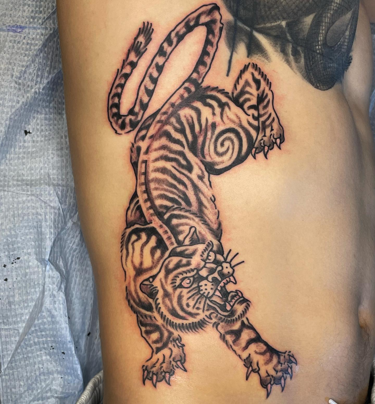 Tiger American traditional tattoo on the ribs by Nicholas M. Passeri