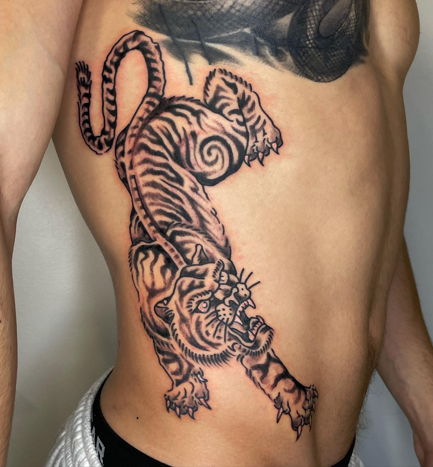 Tiger black and grey tattoo on the ribs by Nicholas M. Passeri