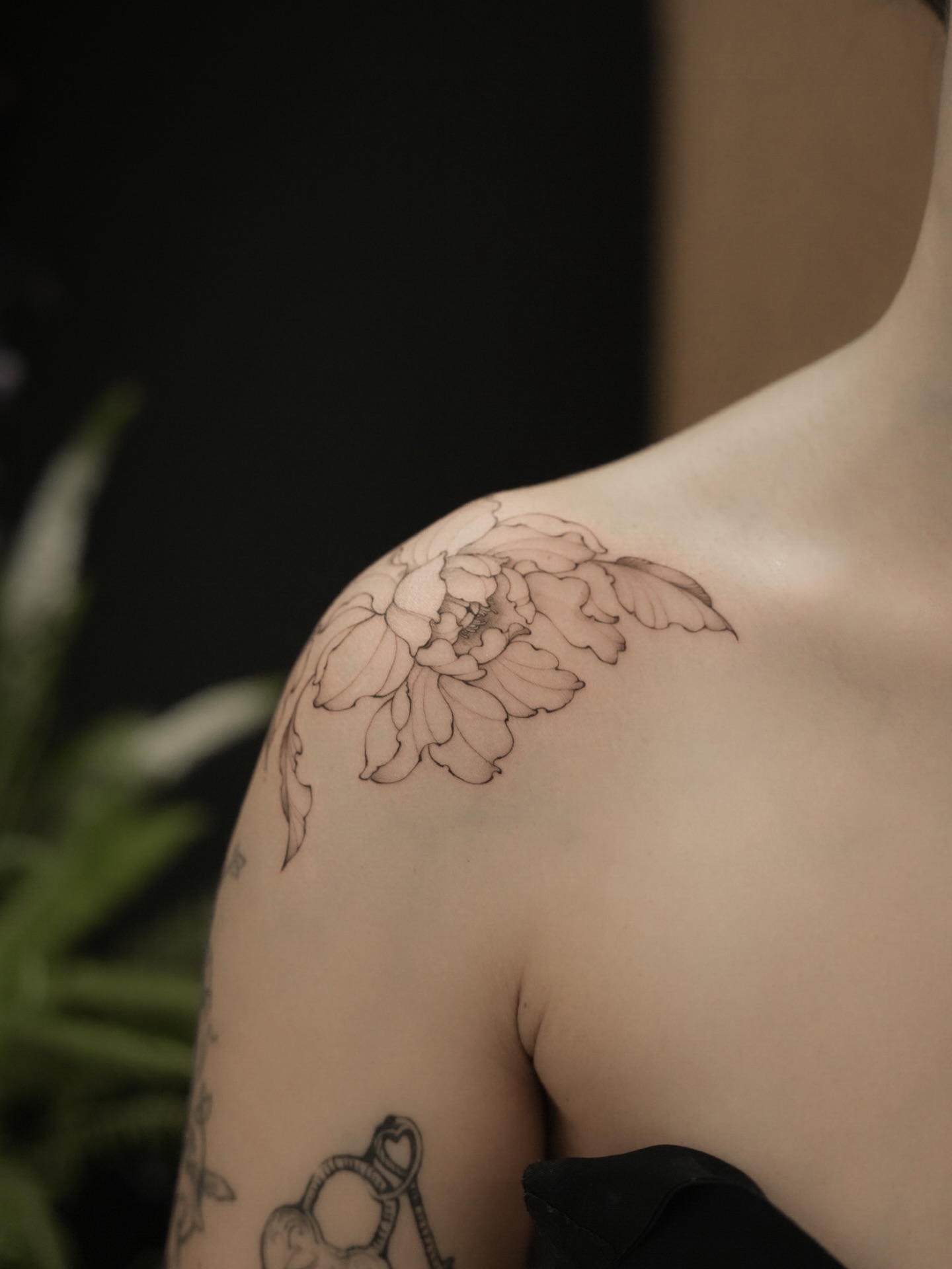 Peony black and grey tattoo on the shoulder by Junh Tattoo NYC