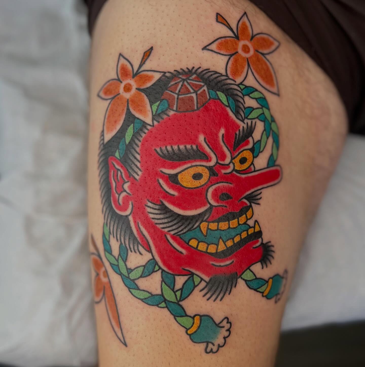 Demon mask American traditional tattoo on the thigh by Mikey Montoya