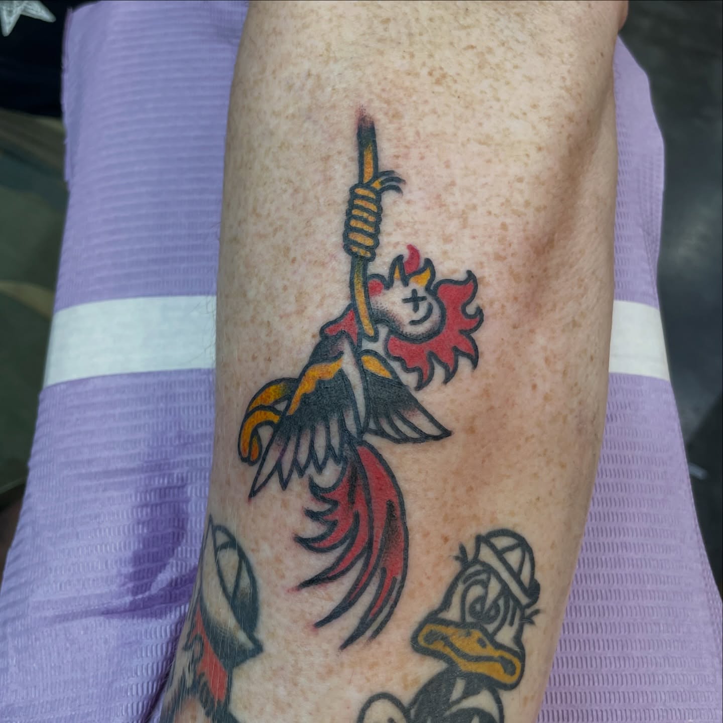 Flaming character American traditional tattoo on the forearm by Greg De Hoot, Youngsville, North Carolina