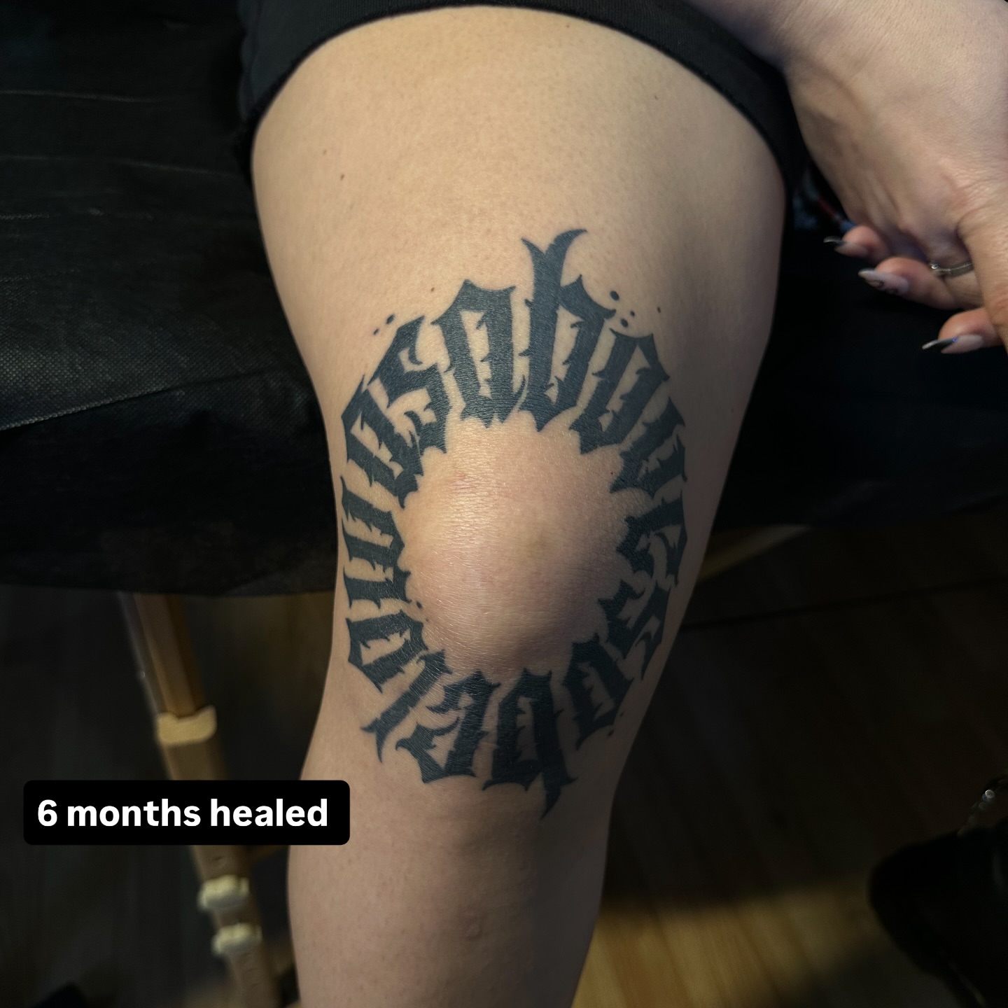 Gothic script black and grey tattoo on the thigh by Yassin alsaje