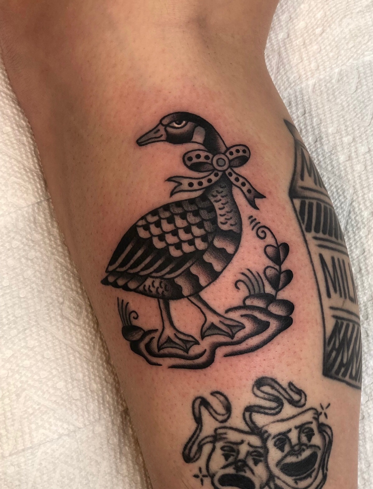 Goose with ribbon American traditional tattoo on the forearm by EVA Traditional Tattoos