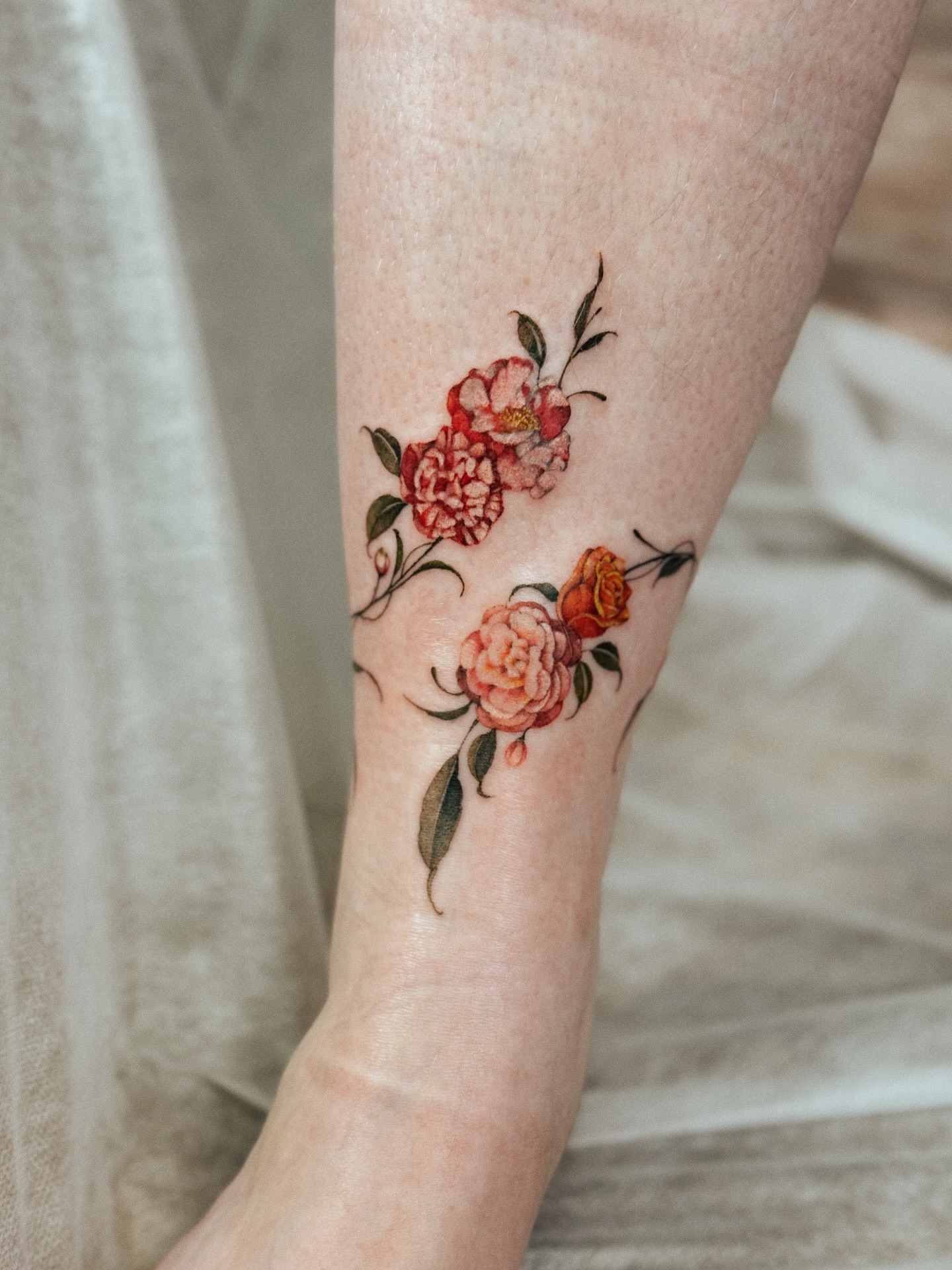 Floral arrangement watercolor tattoo on the forearm by Andrea Evangelista