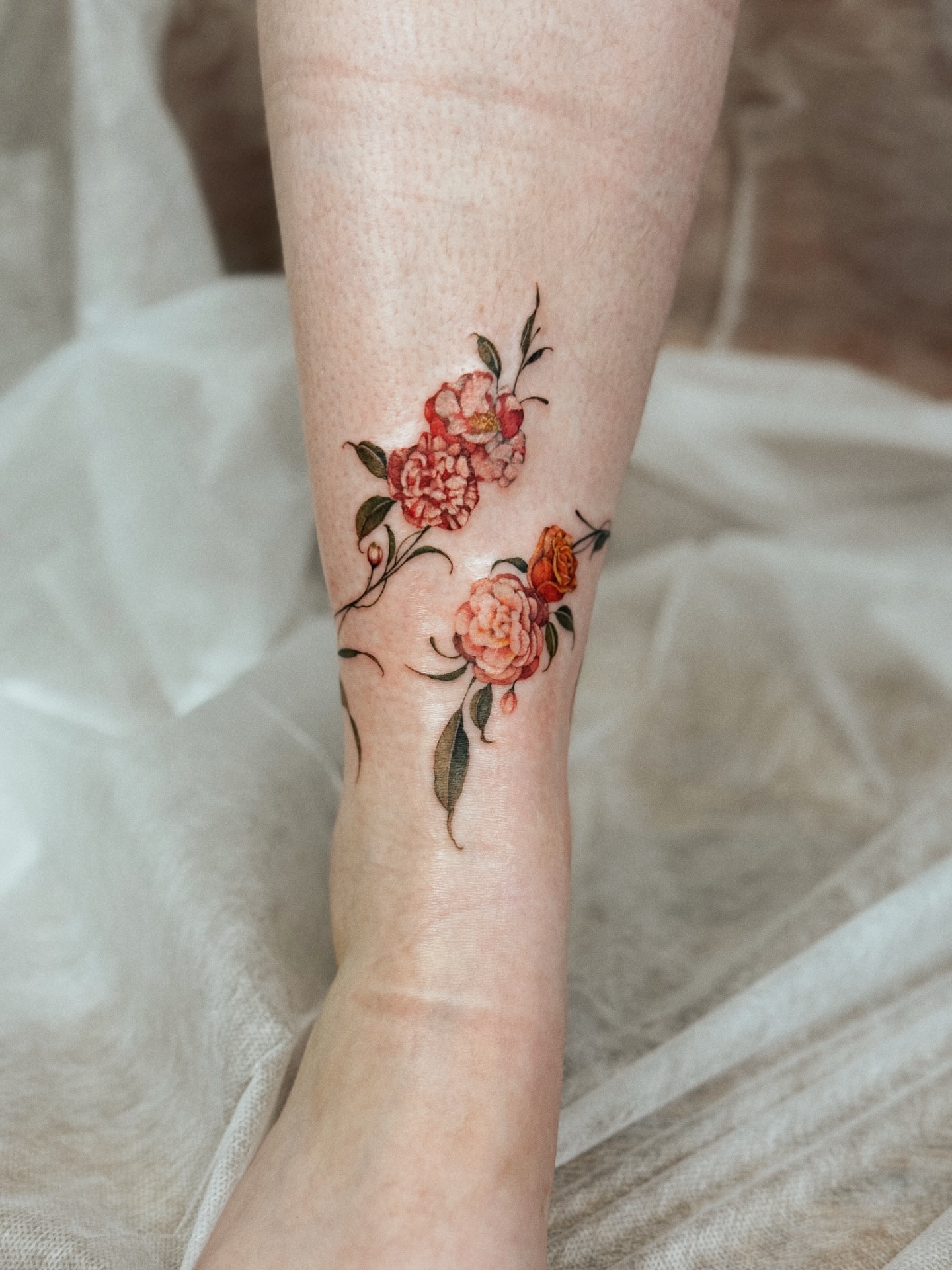 Floral arrangement watercolor tattoo on the forearm by Andrea Evangelista