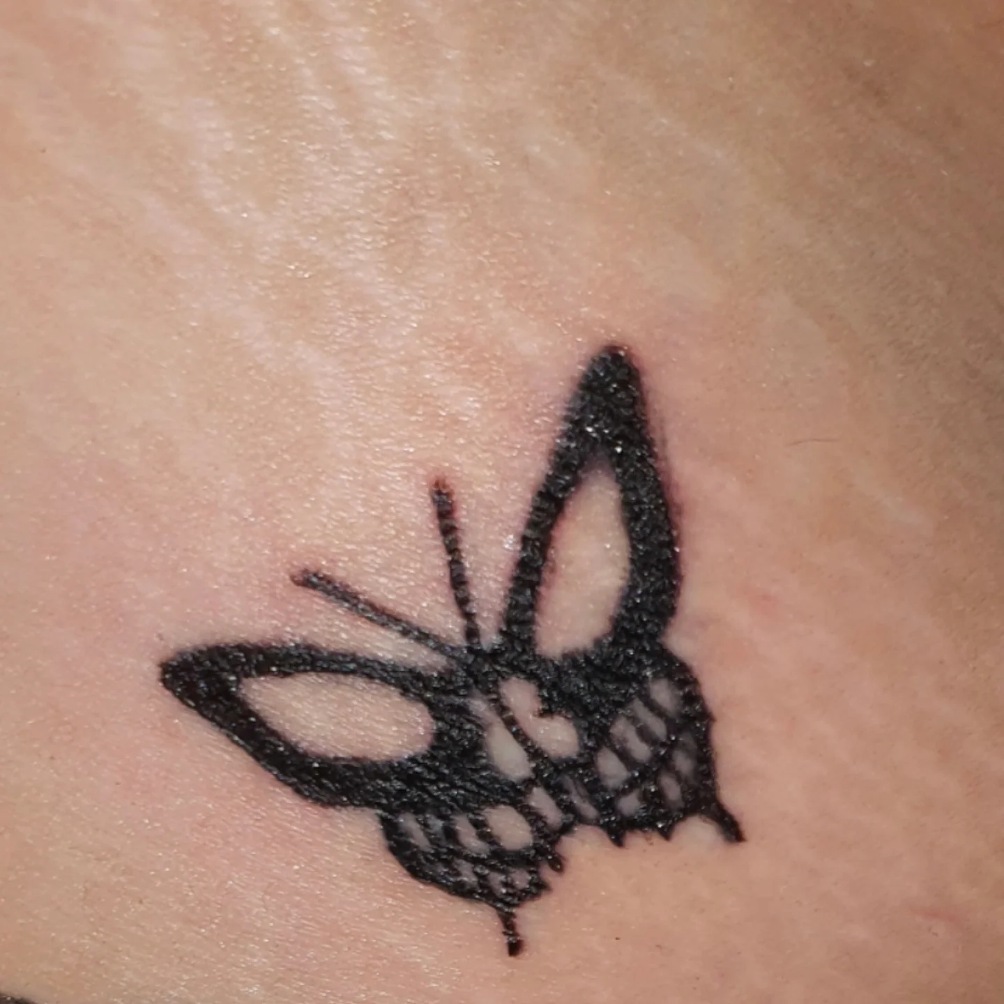 Butterfly dotwork tattoo on the chest by Artful Ink