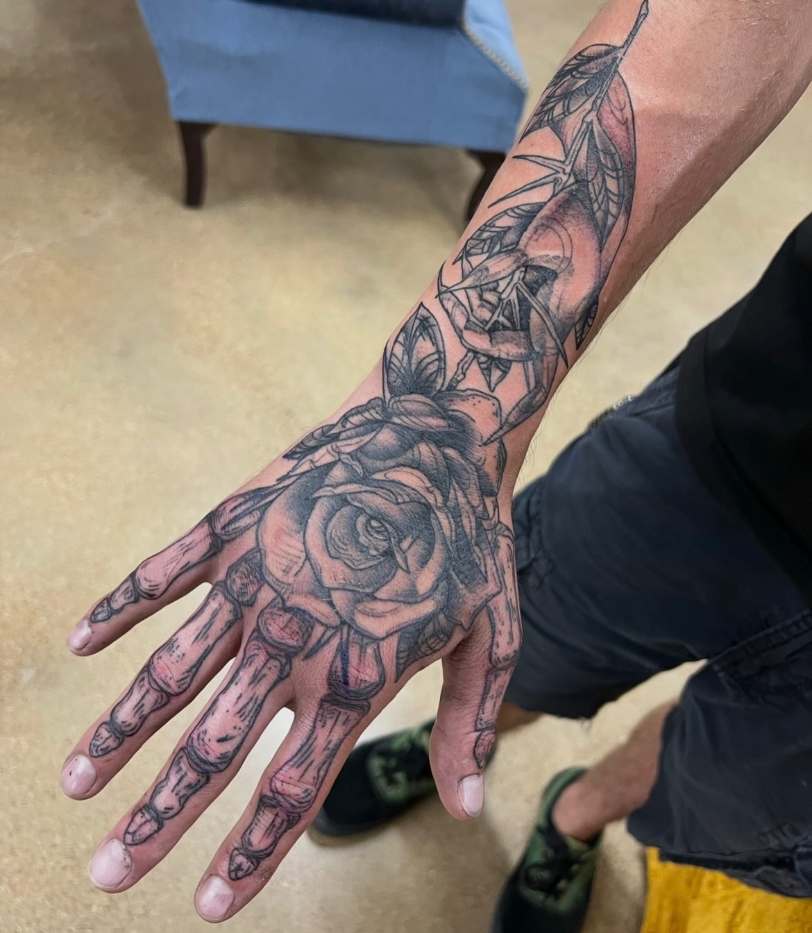 Rose and skeleton hand realism tattoo on the hand by Andrea Patterson