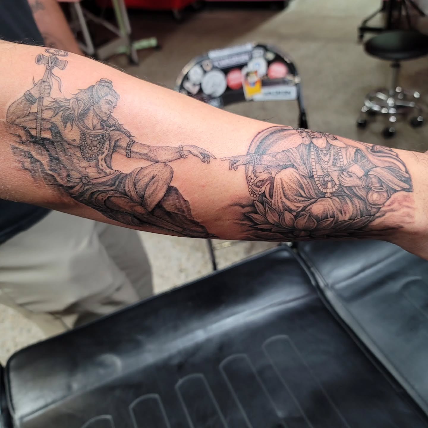 Deity interaction realism tattoo on the forearm by Mary Lefeau