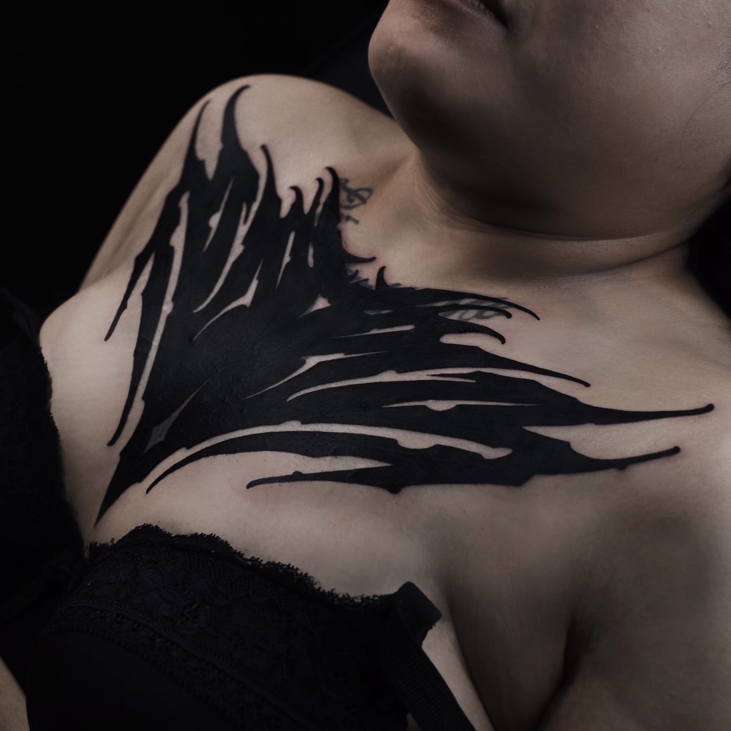 Abstract flame blackwork tattoo on the chest by Zlata