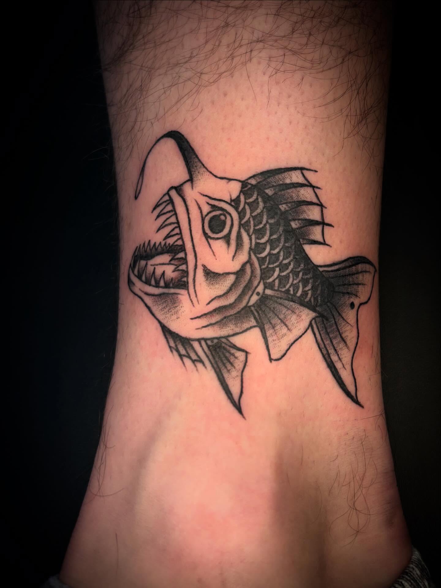 Piranha black and grey tattoo on the forearm by Brett Ferguson