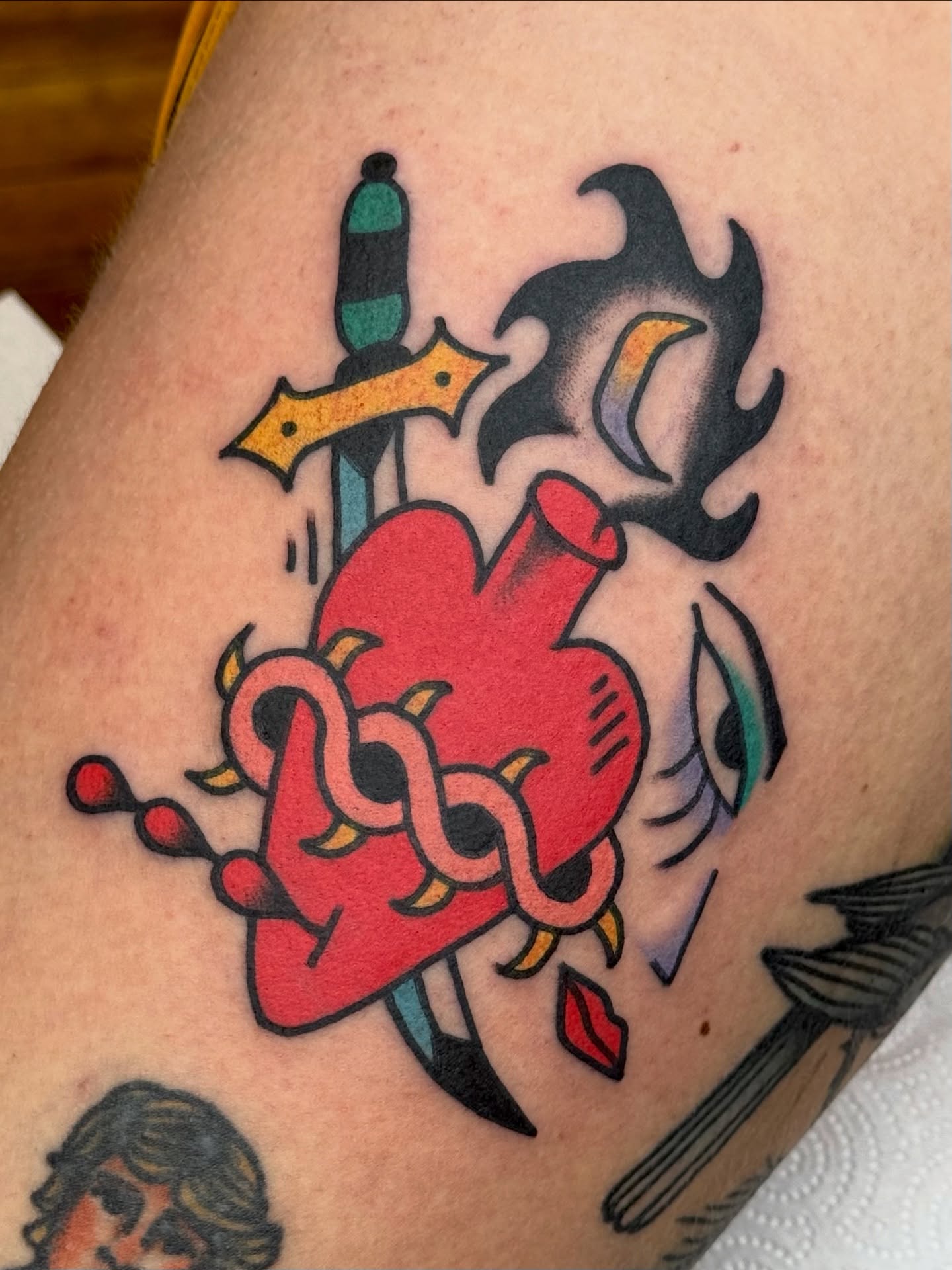 Heart with dagger American traditional tattoo on the thigh by Roman