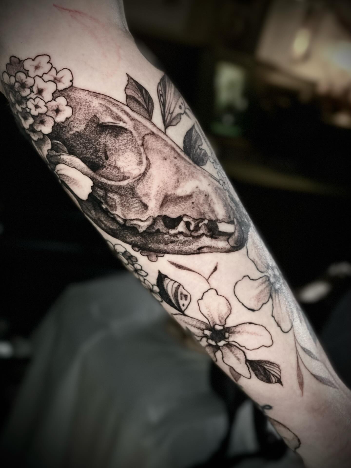 Animal skull with floral elements realism tattoo on the forearm by Olivia Scott - Kansas Tattoo Artist