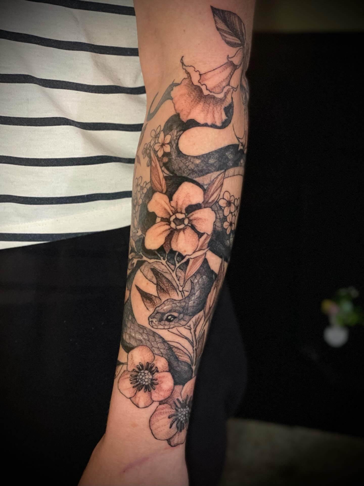 Snake and flowers neo-traditional tattoo on the forearm by Olivia Scott - Kansas Tattoo Artist