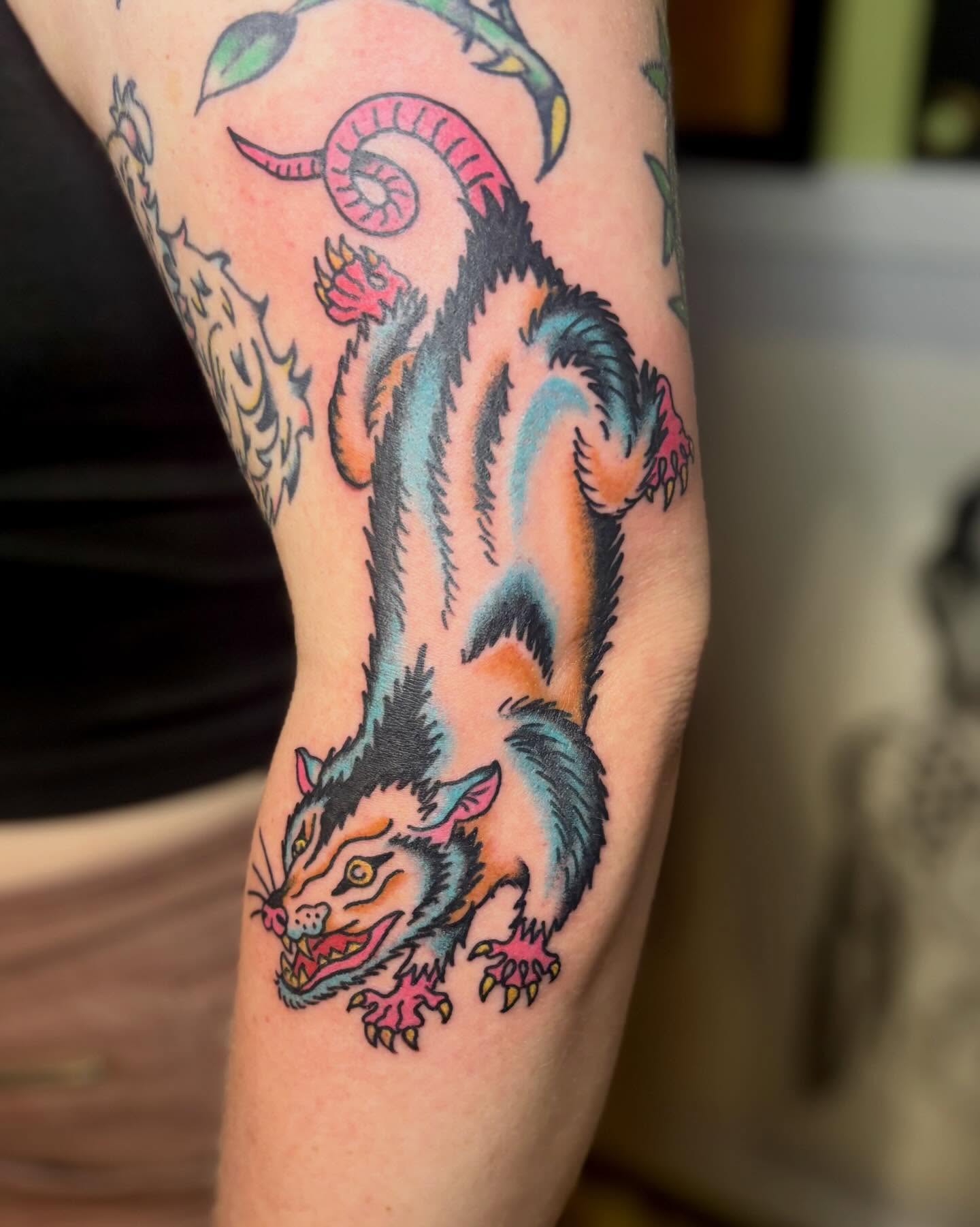 Cat-like creature American traditional tattoo on the forearm by Tia Cave