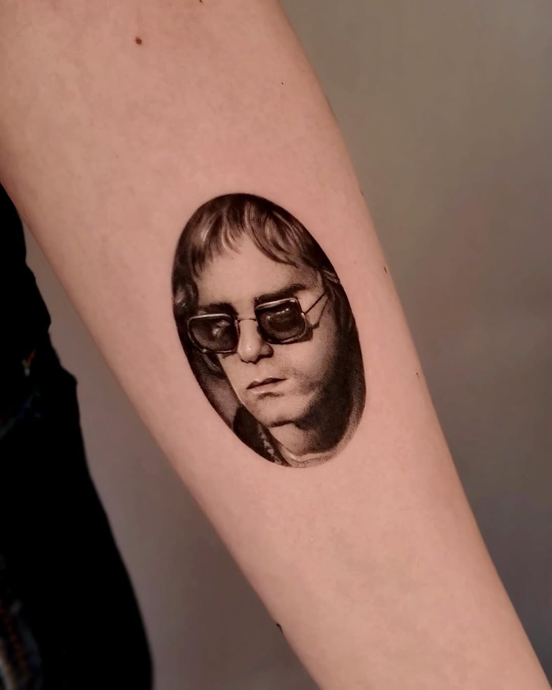 Portrait of Elton John realism tattoo on the forearm by Gabriel