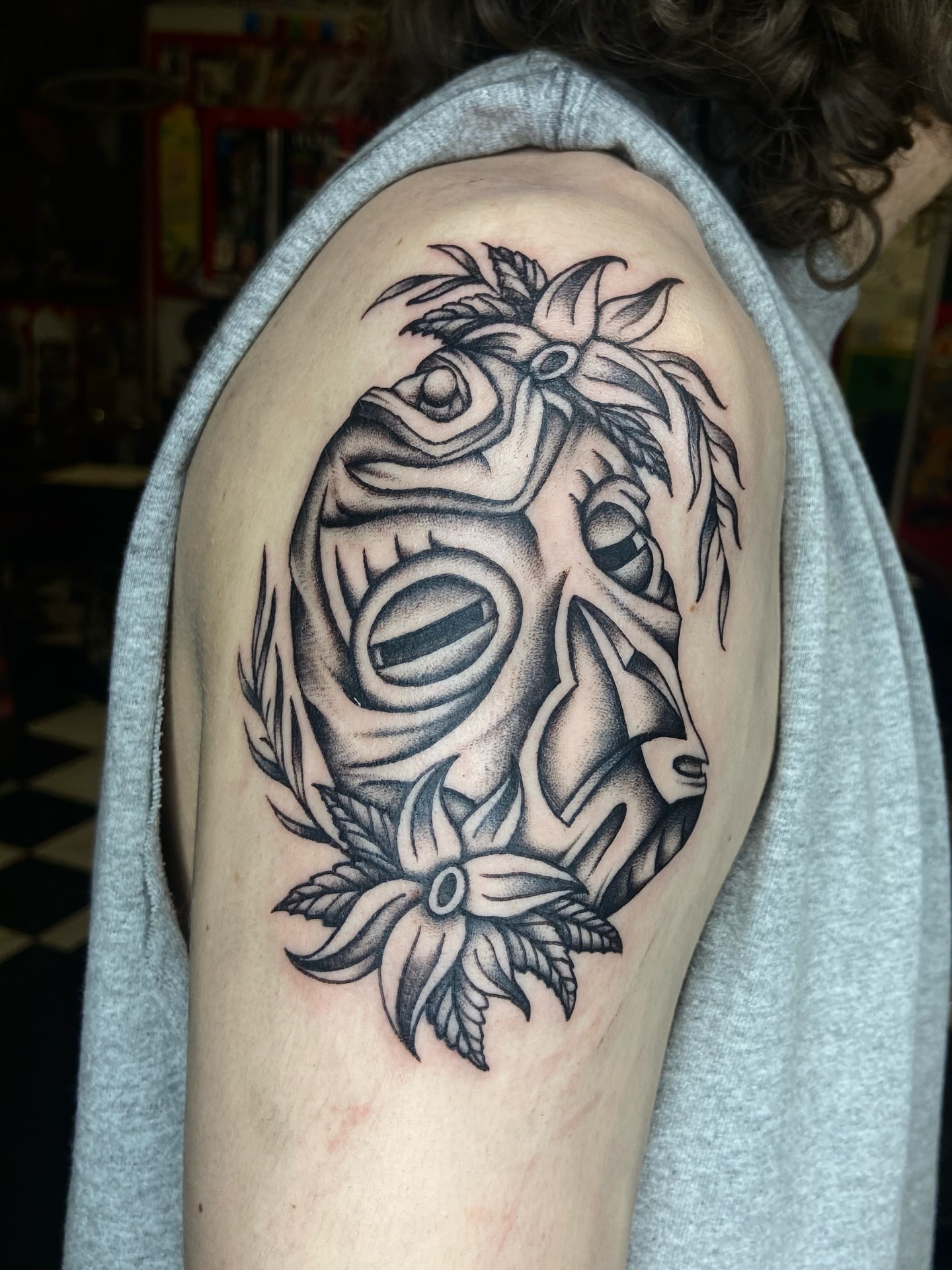 Mask with floral elements realism tattoo on the shoulder by R y a n S m i t h