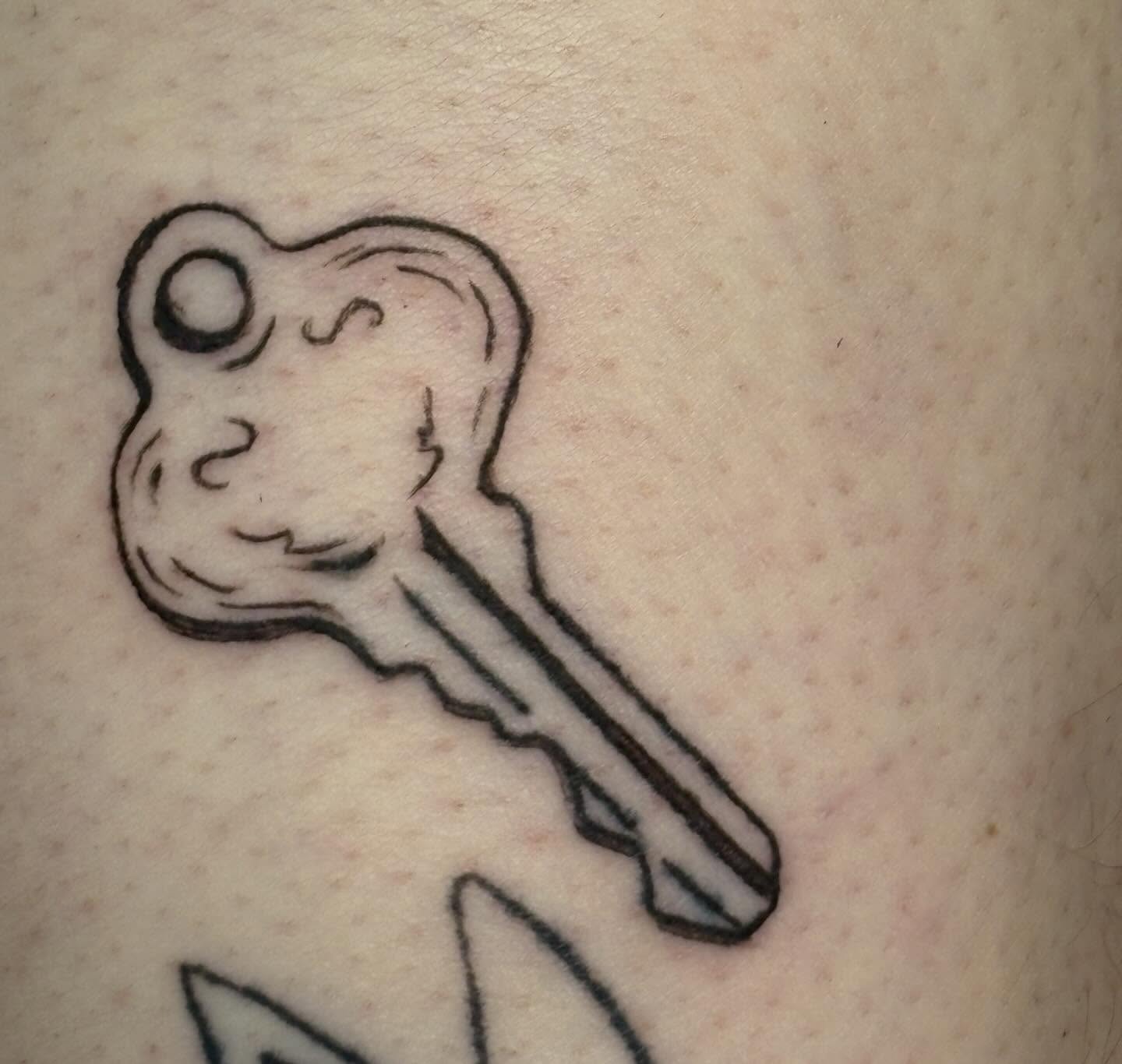 Key with frog head black and grey tattoo on the forearm by izzy solae