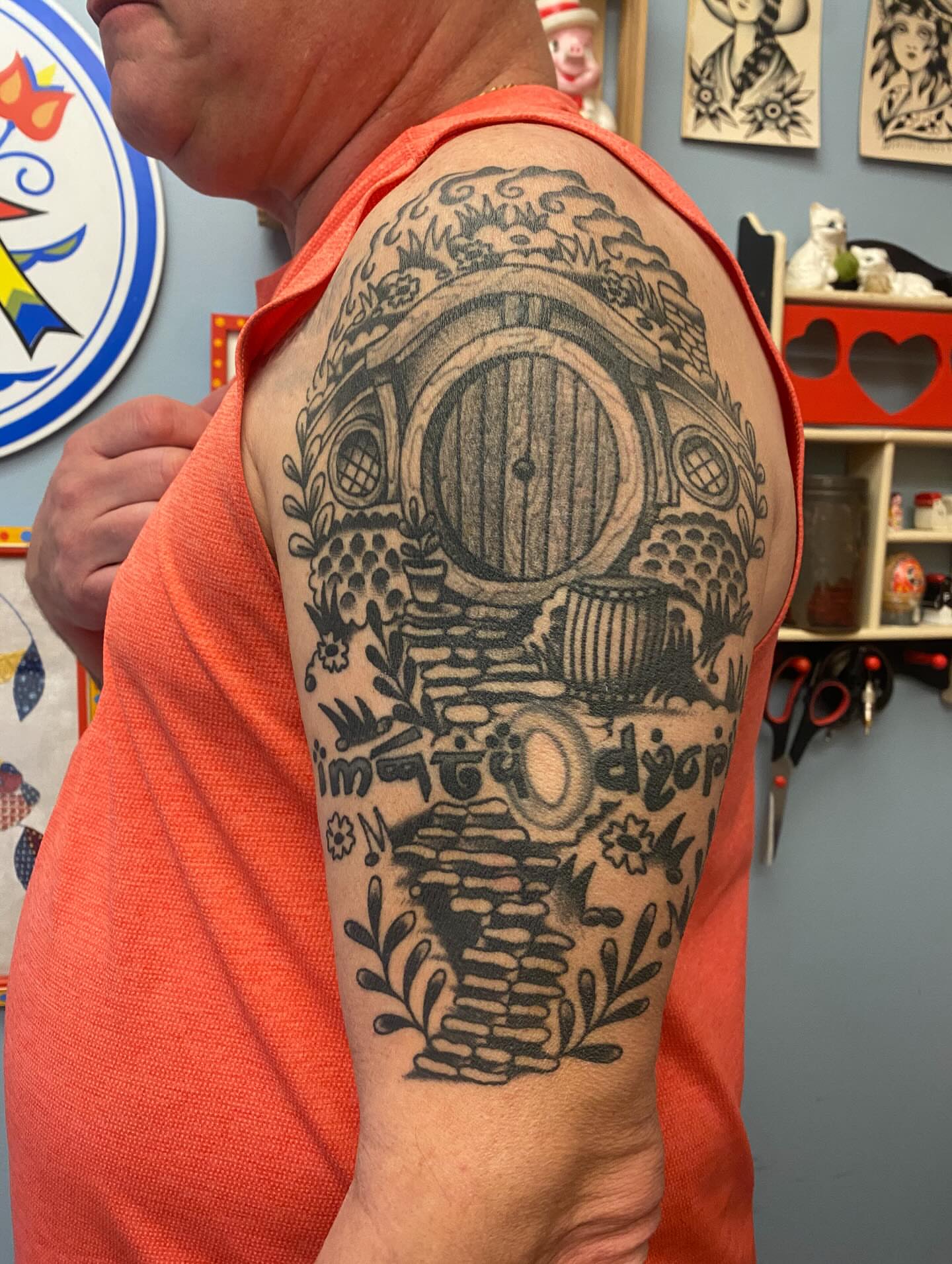 Hobbit house black and grey tattoo on the upper arm by Abby Rose Estes