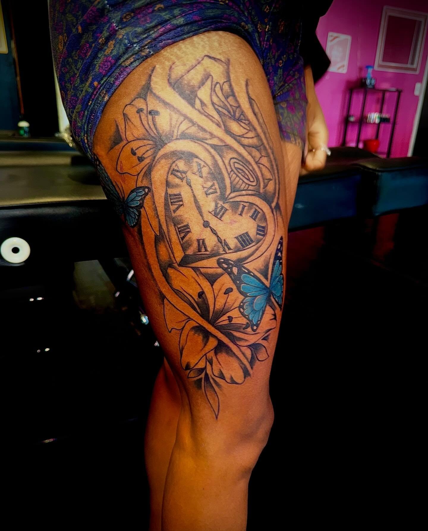 Clock and flowers realism tattoo on the thigh by Clifford Jordan
