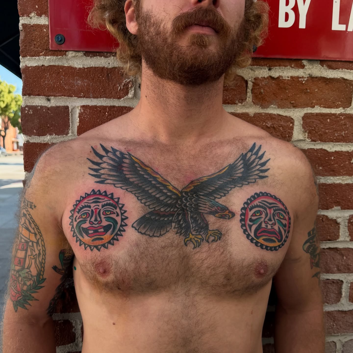 Eagle and sun faces American traditional tattoo on the chest by Erik Sheppard
