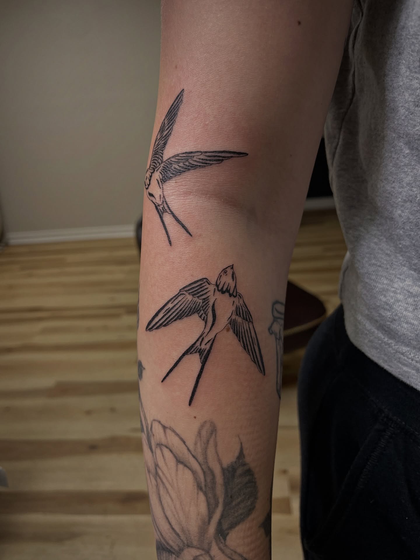 Swallows black and grey tattoo on the forearm by Francesca Siwa