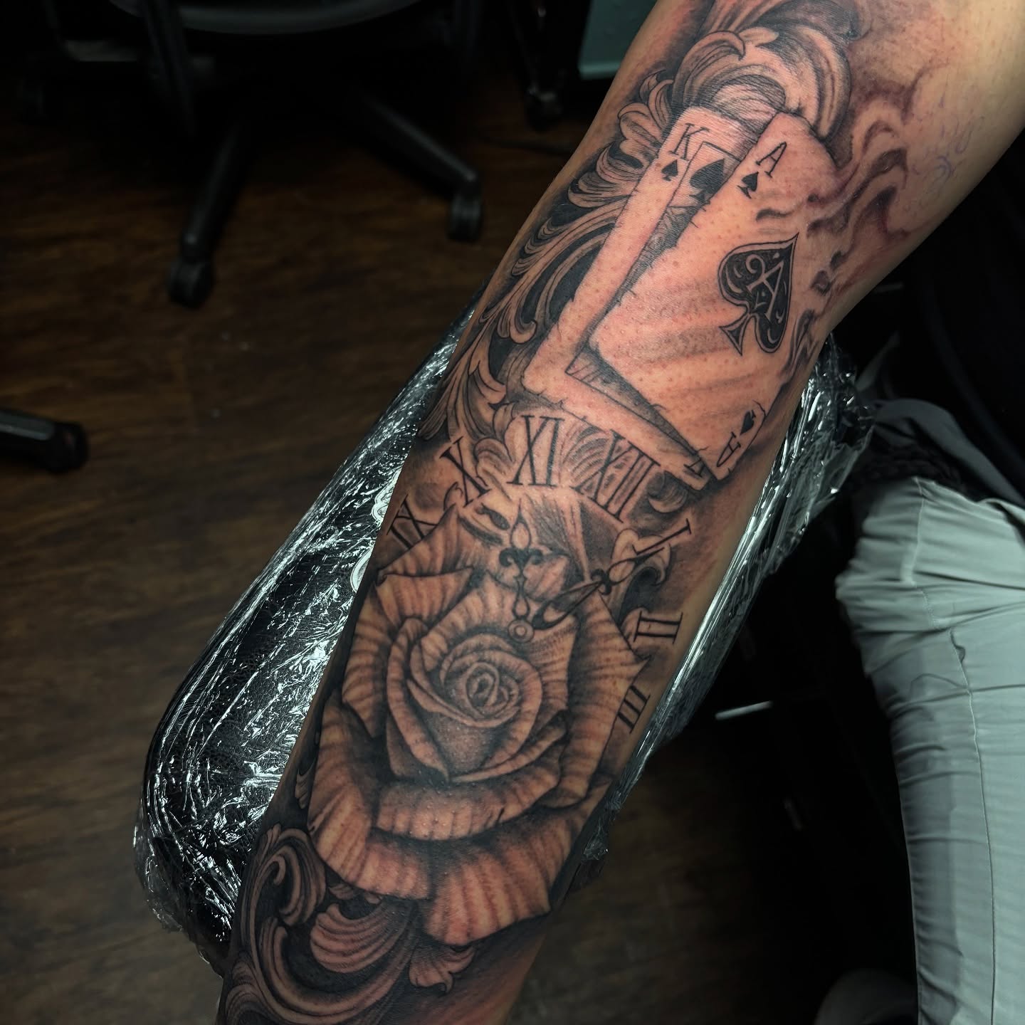 Clock, playing cards, rose realism tattoo on the forearm by Terik Whittaker