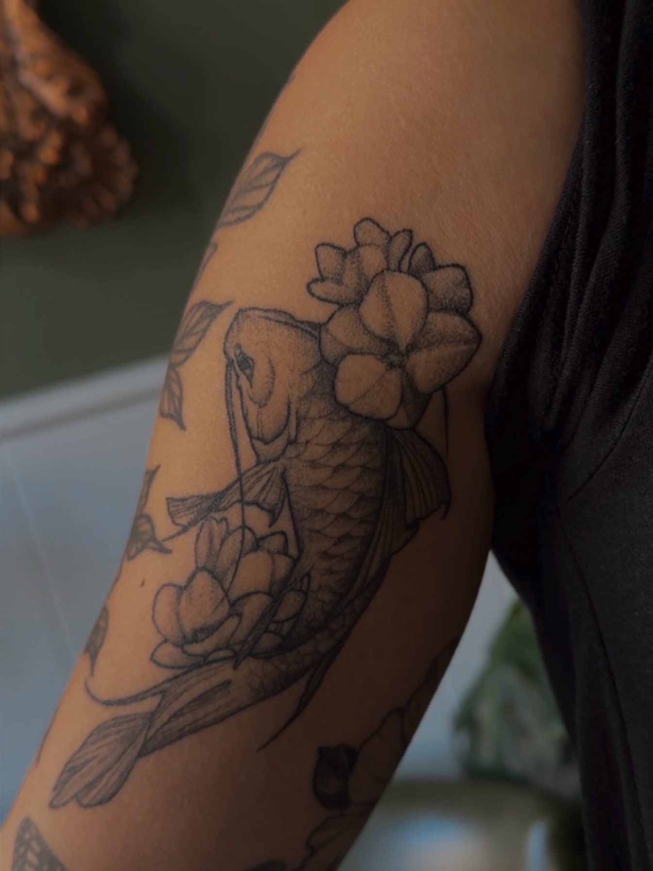 Koi fish and flowers black and grey tattoo on the forearm by Allexis
