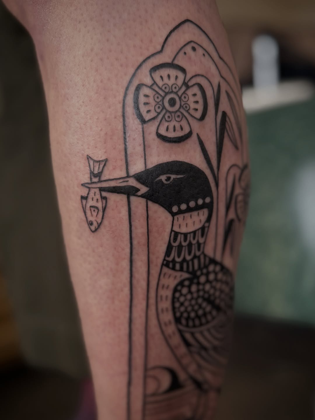 Loon with fish fine line tattoo on the forearm by Leah - Tattoo Artist