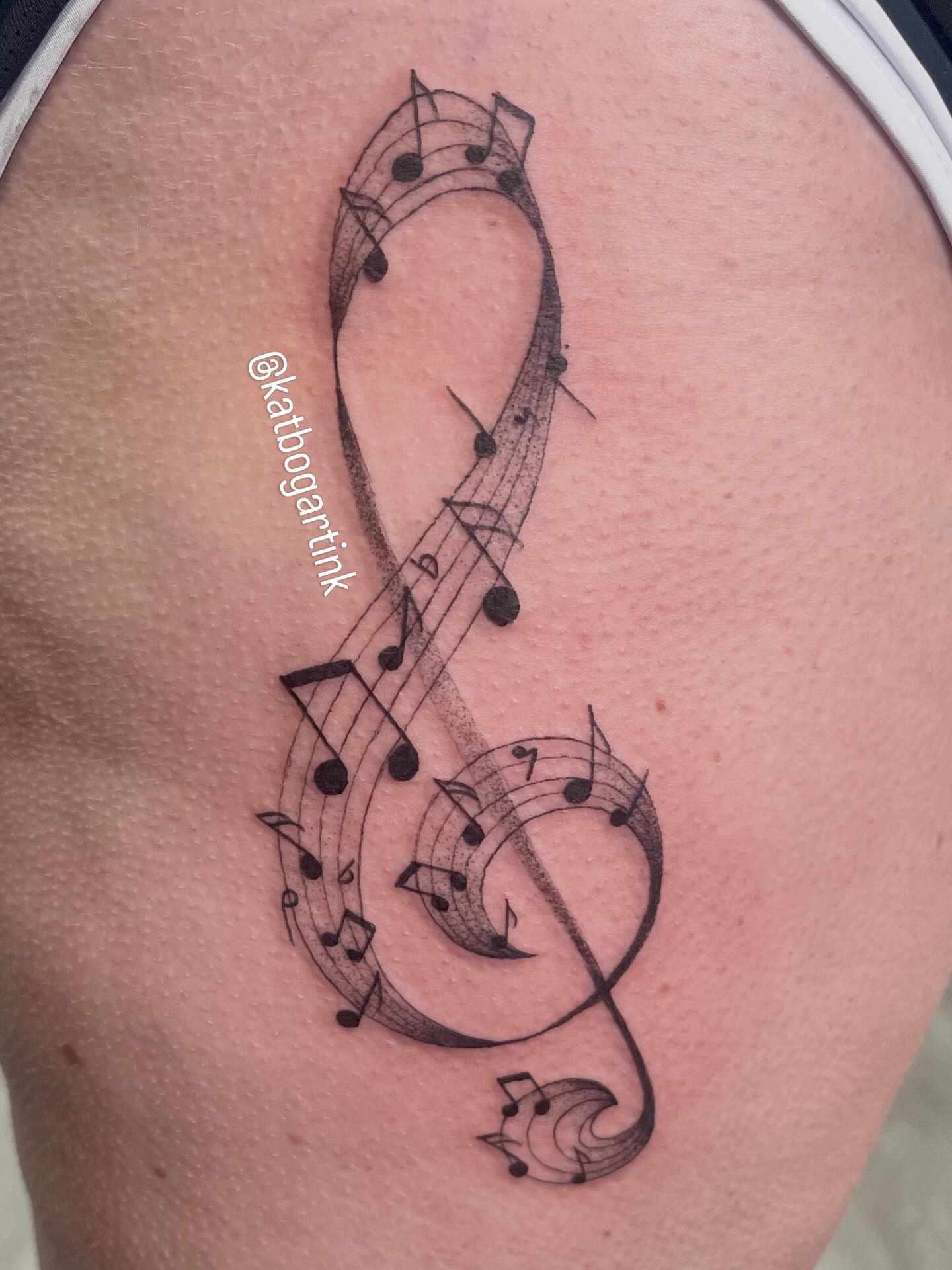 Music notes black and grey tattoo on the shoulder by Kat (Scout) Bogart