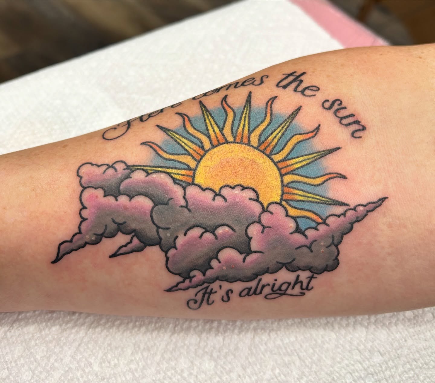 Sun and clouds new school tattoo on the forearm by Courtney