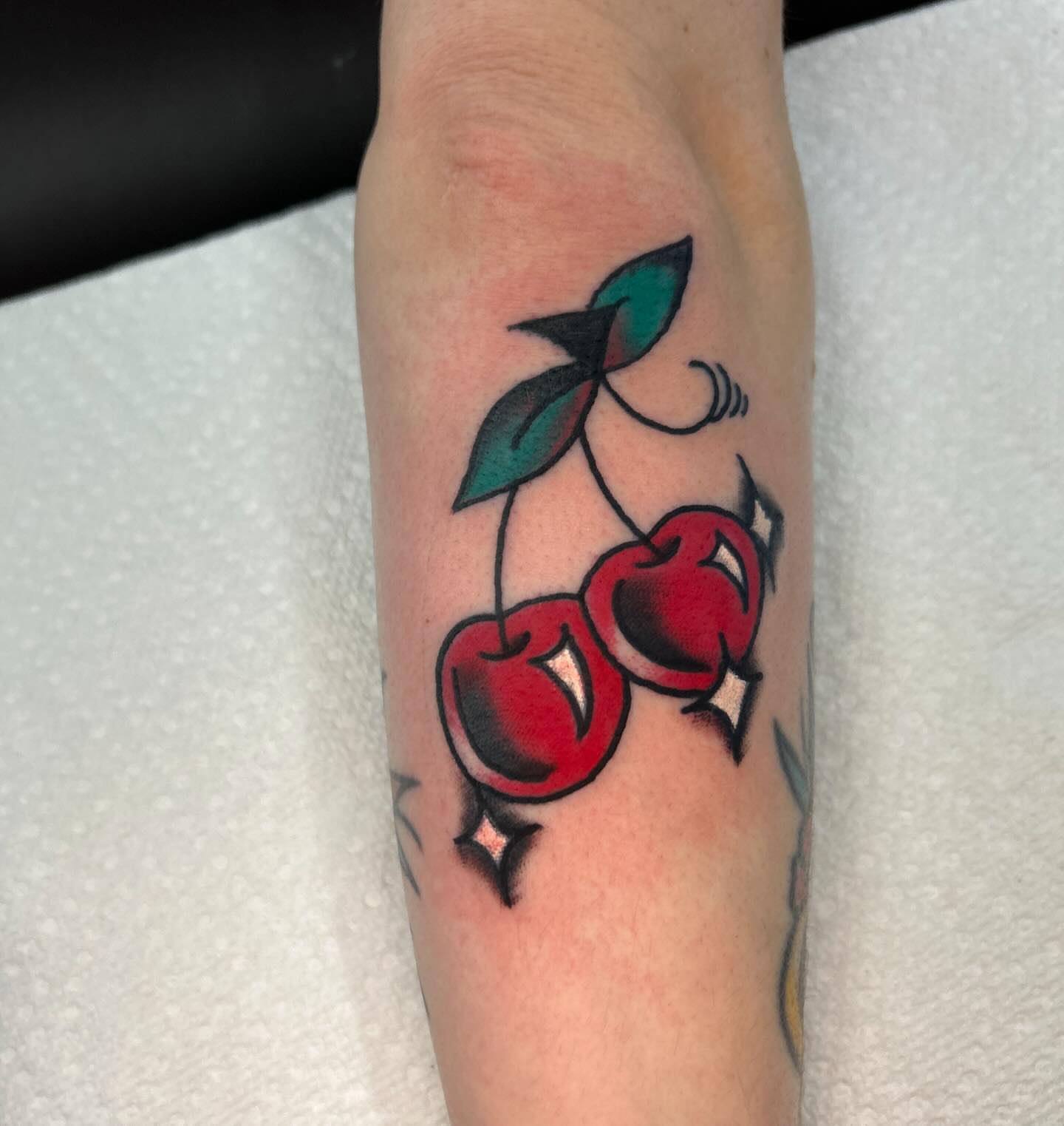 Cherry American traditional tattoo on the forearm by Dylan O'Quin