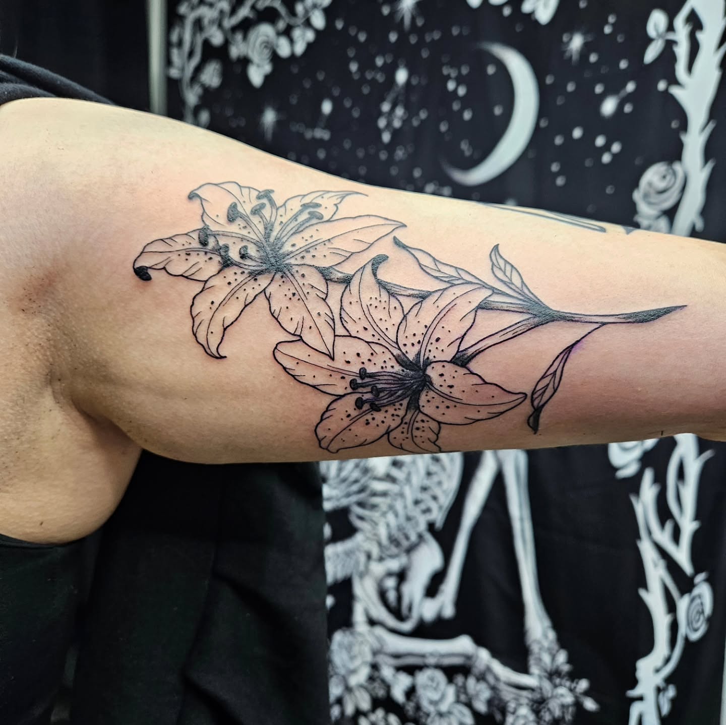 Lilies black and grey tattoo on the forearm by Danny
