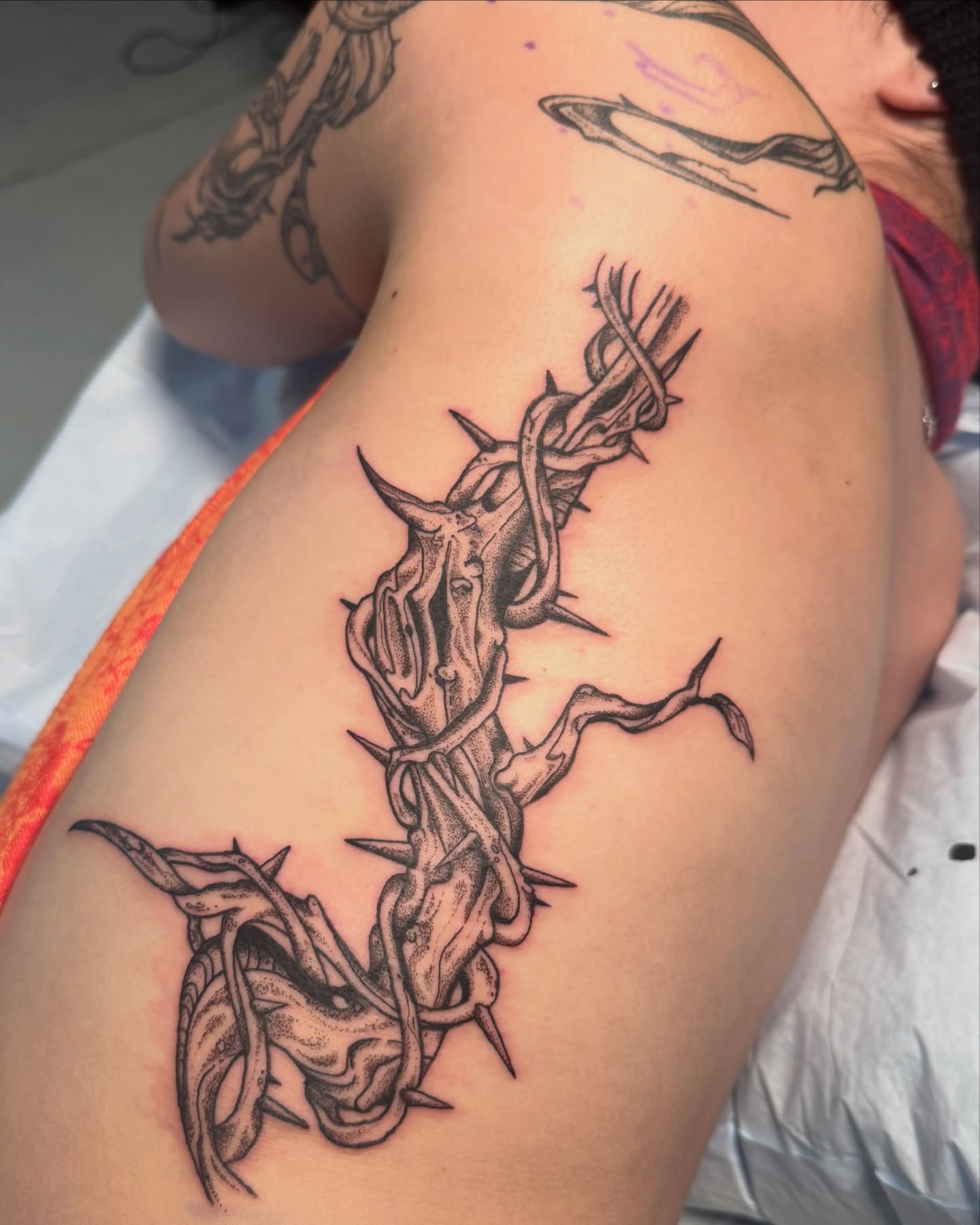 Thorned branch realism tattoo on the thigh by jake.inks