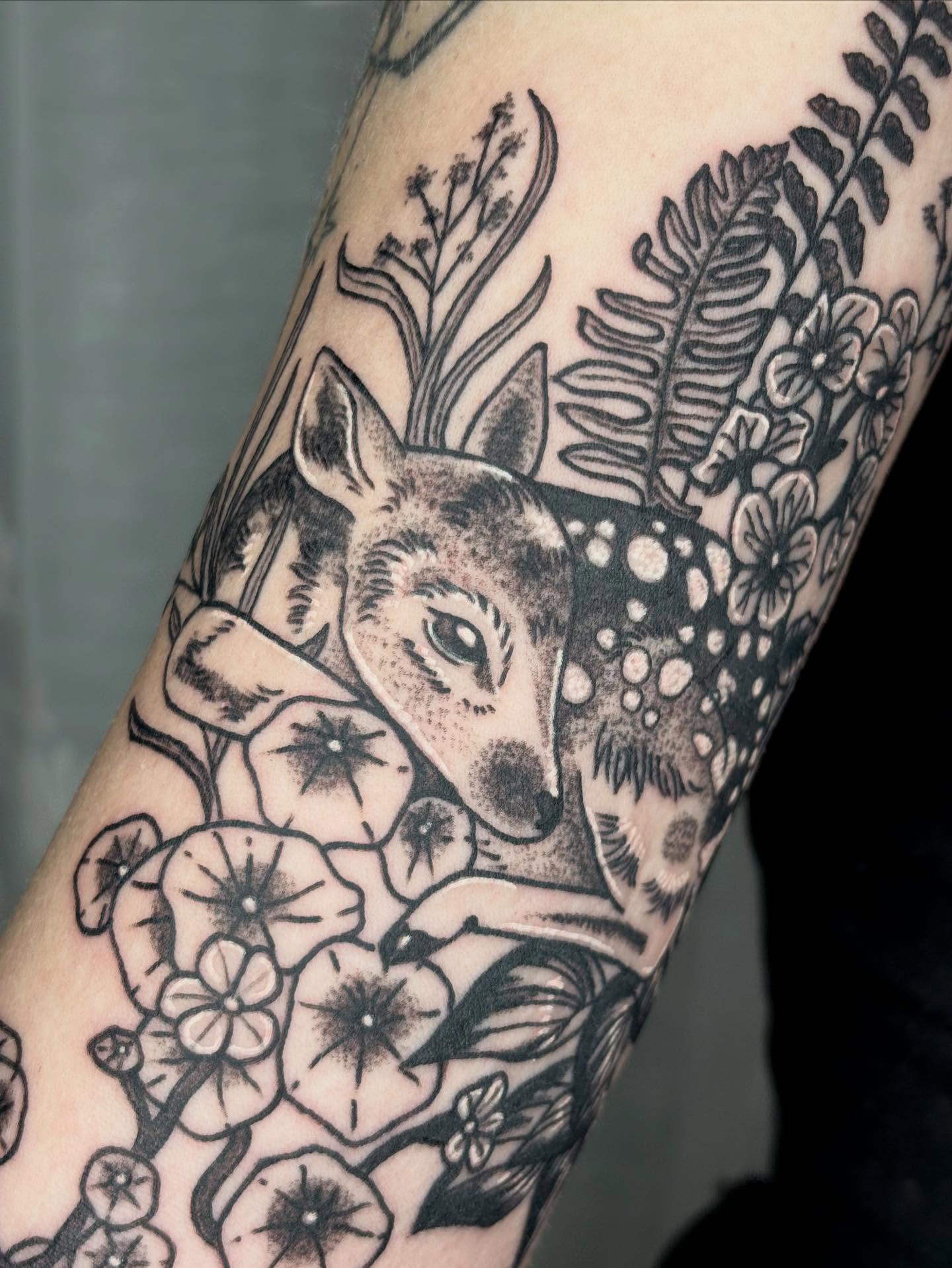 Deer and floral realism tattoo on the forearm by destiney rose