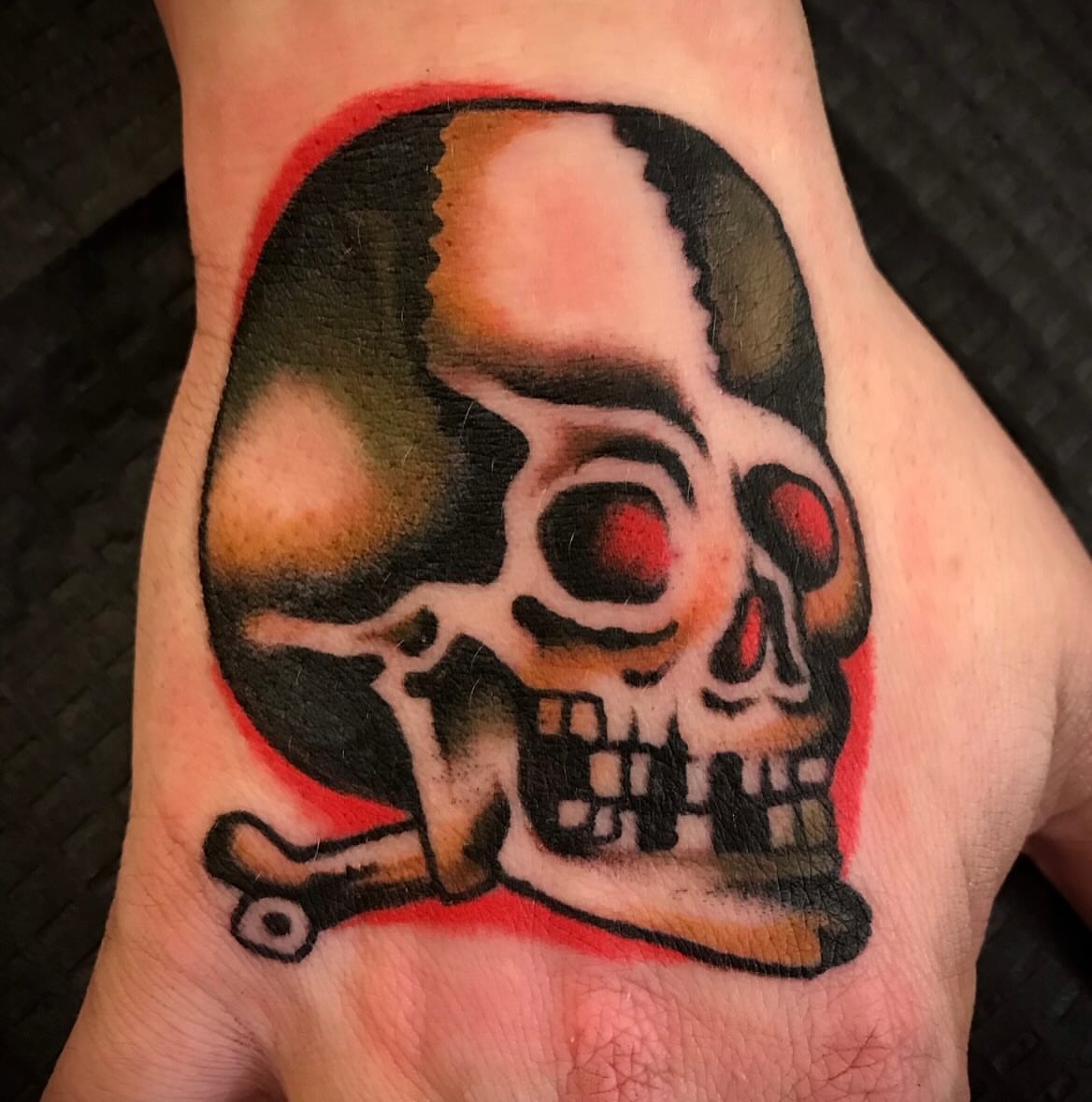 Skull and crossbones American traditional tattoo on the hand by JohnJohn