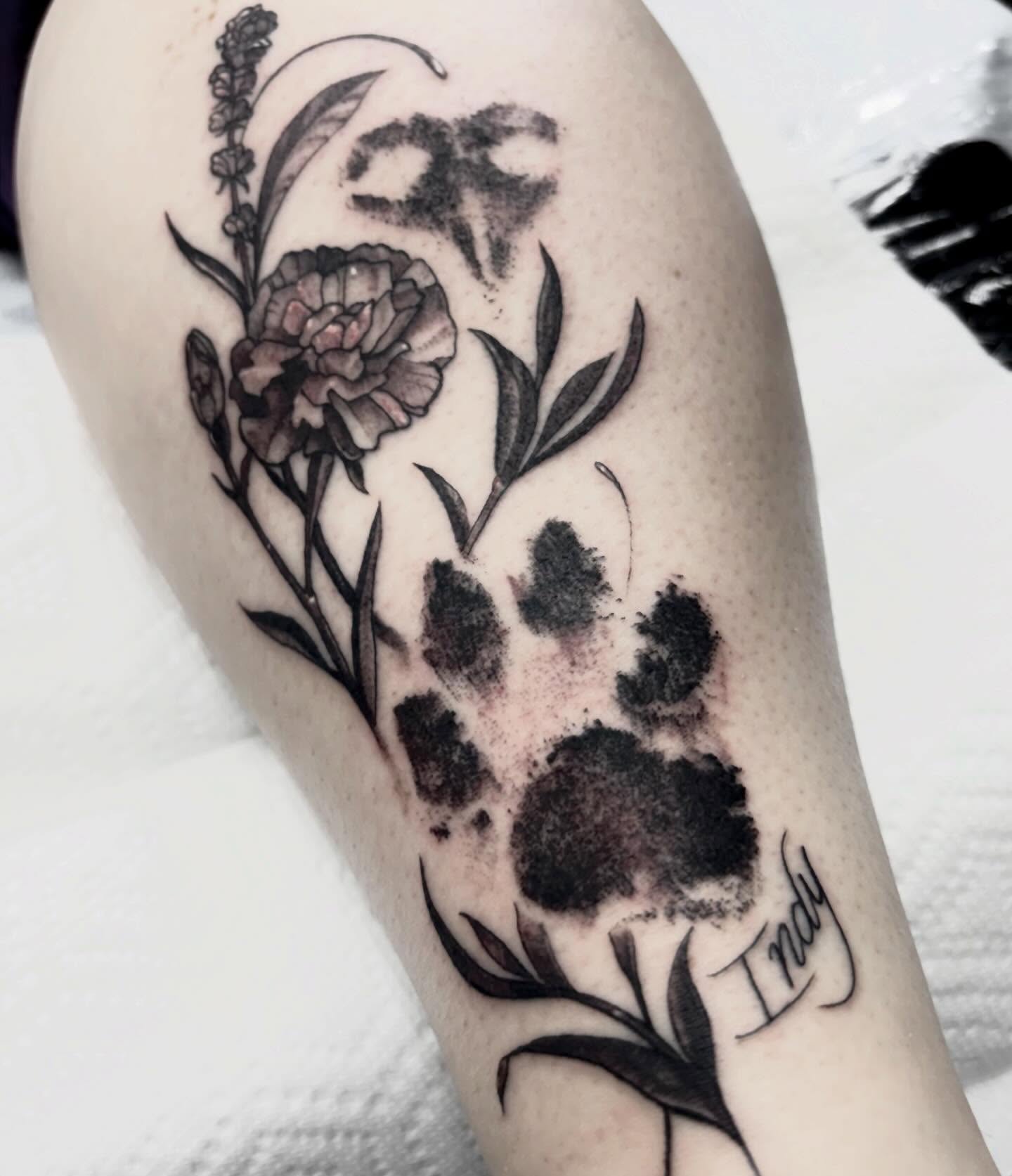 Flower and paw print black and grey tattoo on the forearm by Alle