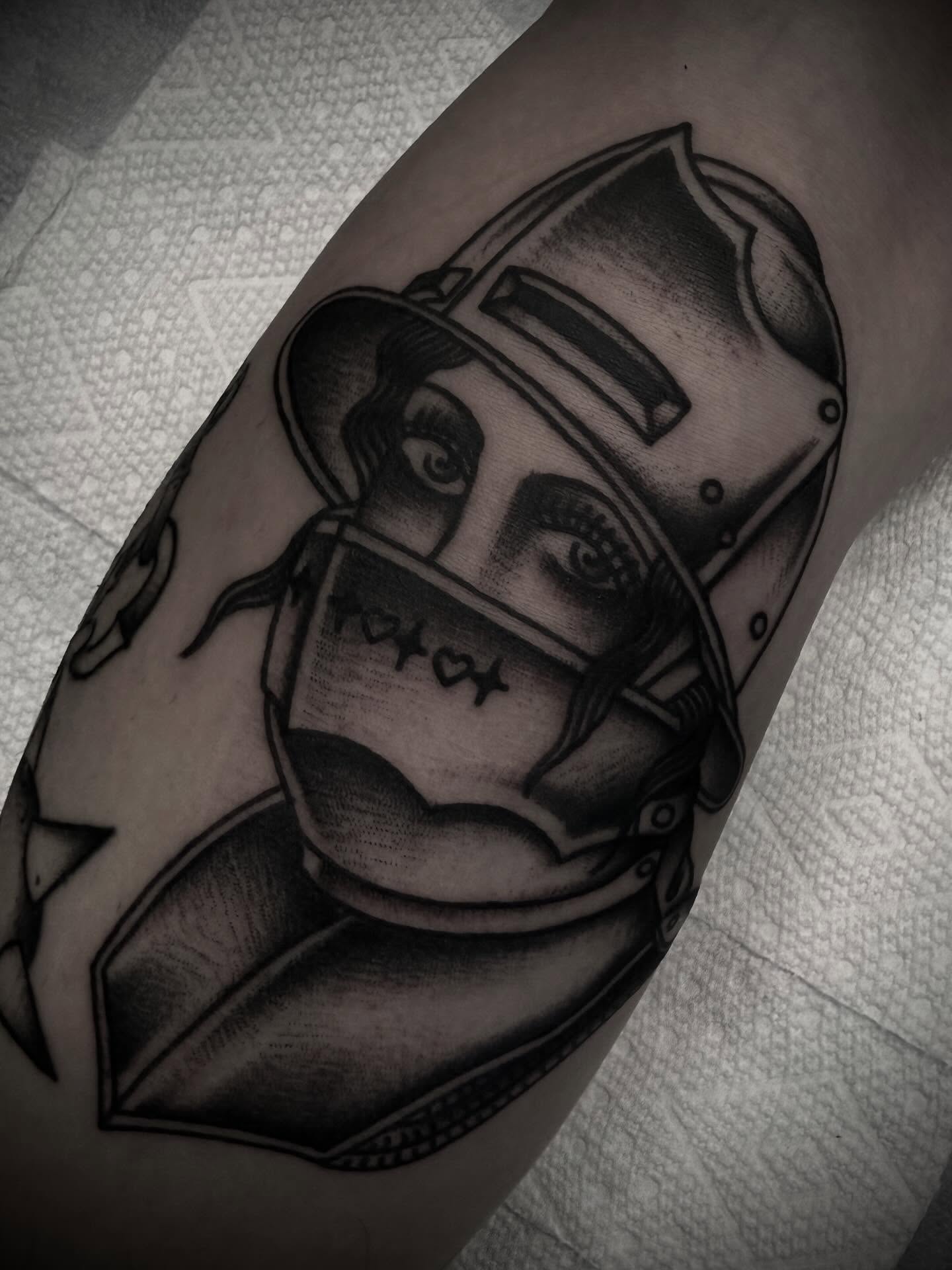 Firefighter helmet black and grey tattoo on the forearm by Andrew Slater