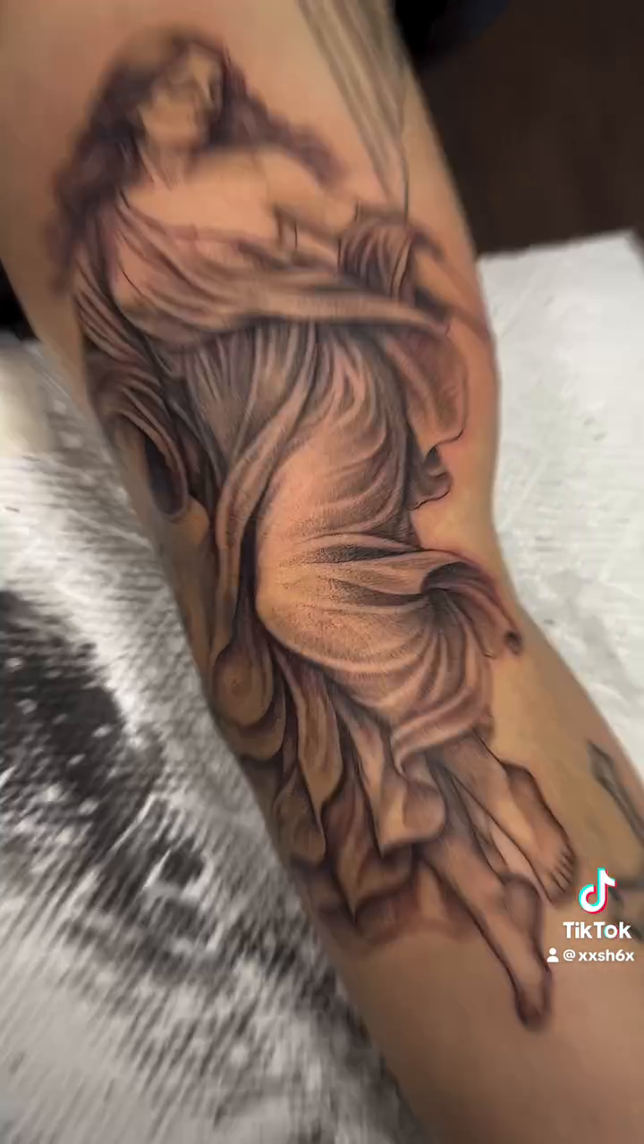 Woman with flowing drapery realism tattoo by sydney honn