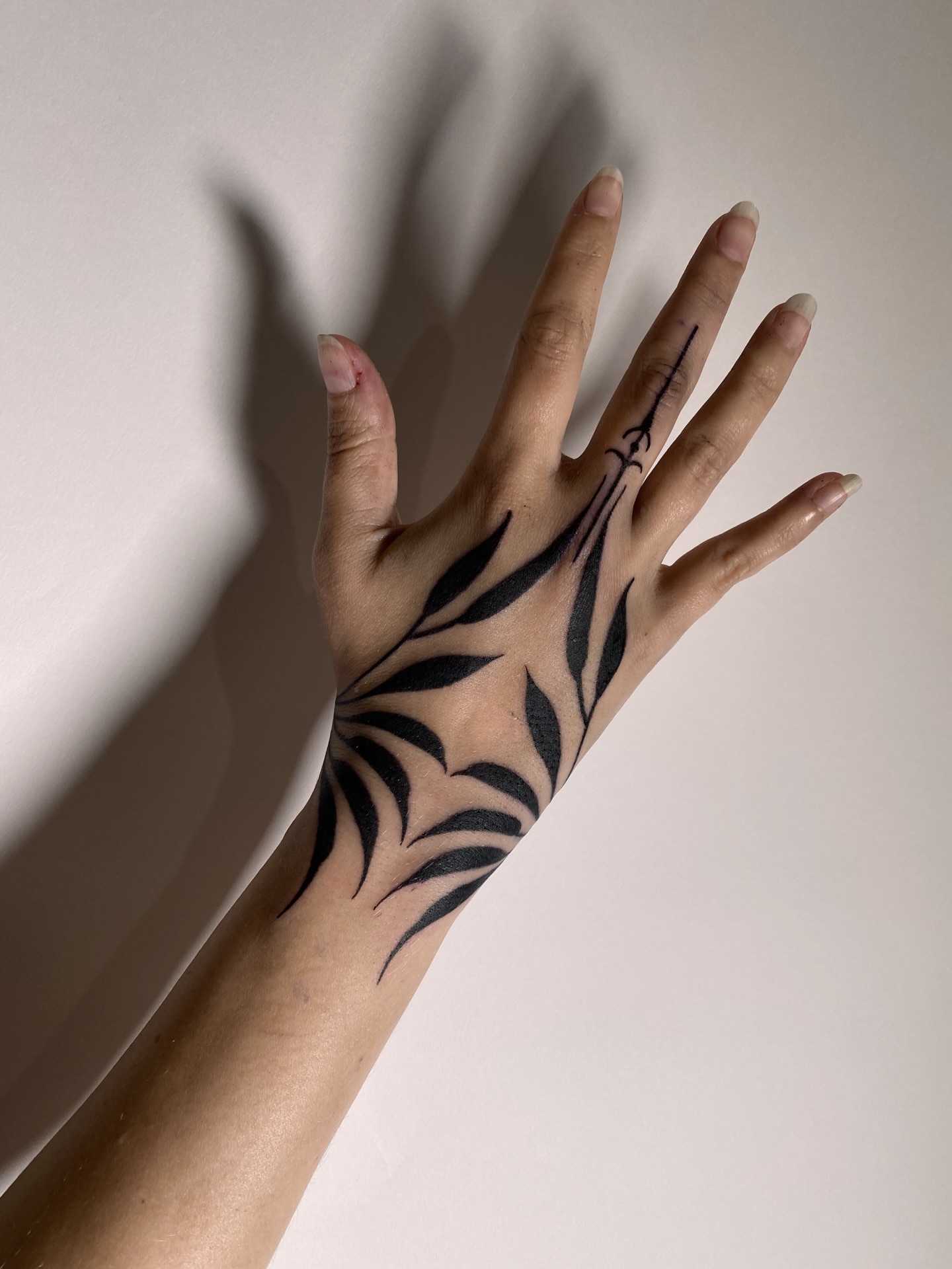 Leaf pattern black and grey tattoo on the hand by Natasha Dickinson
