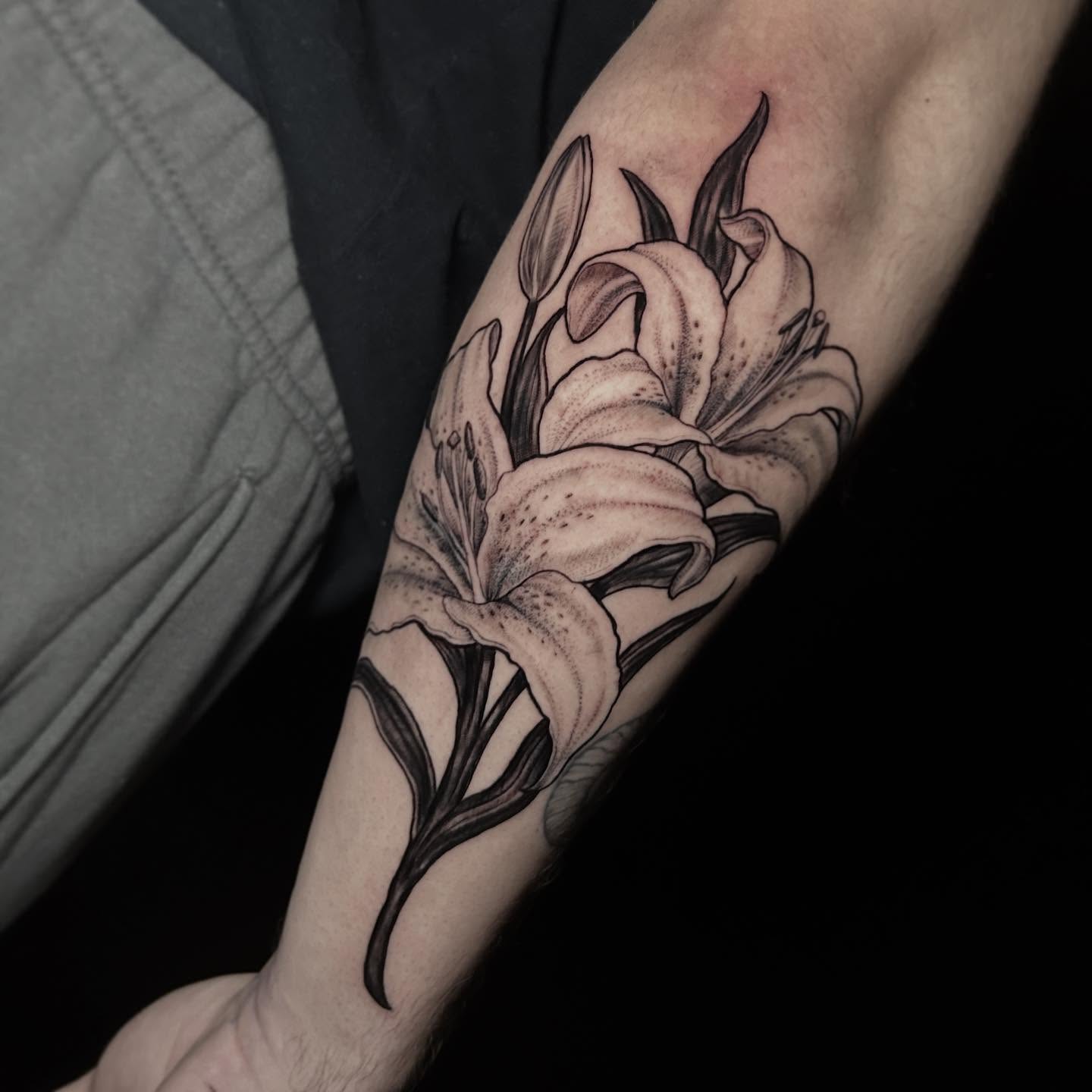 Lily black and grey tattoo on the forearm by Ashlee Mshar