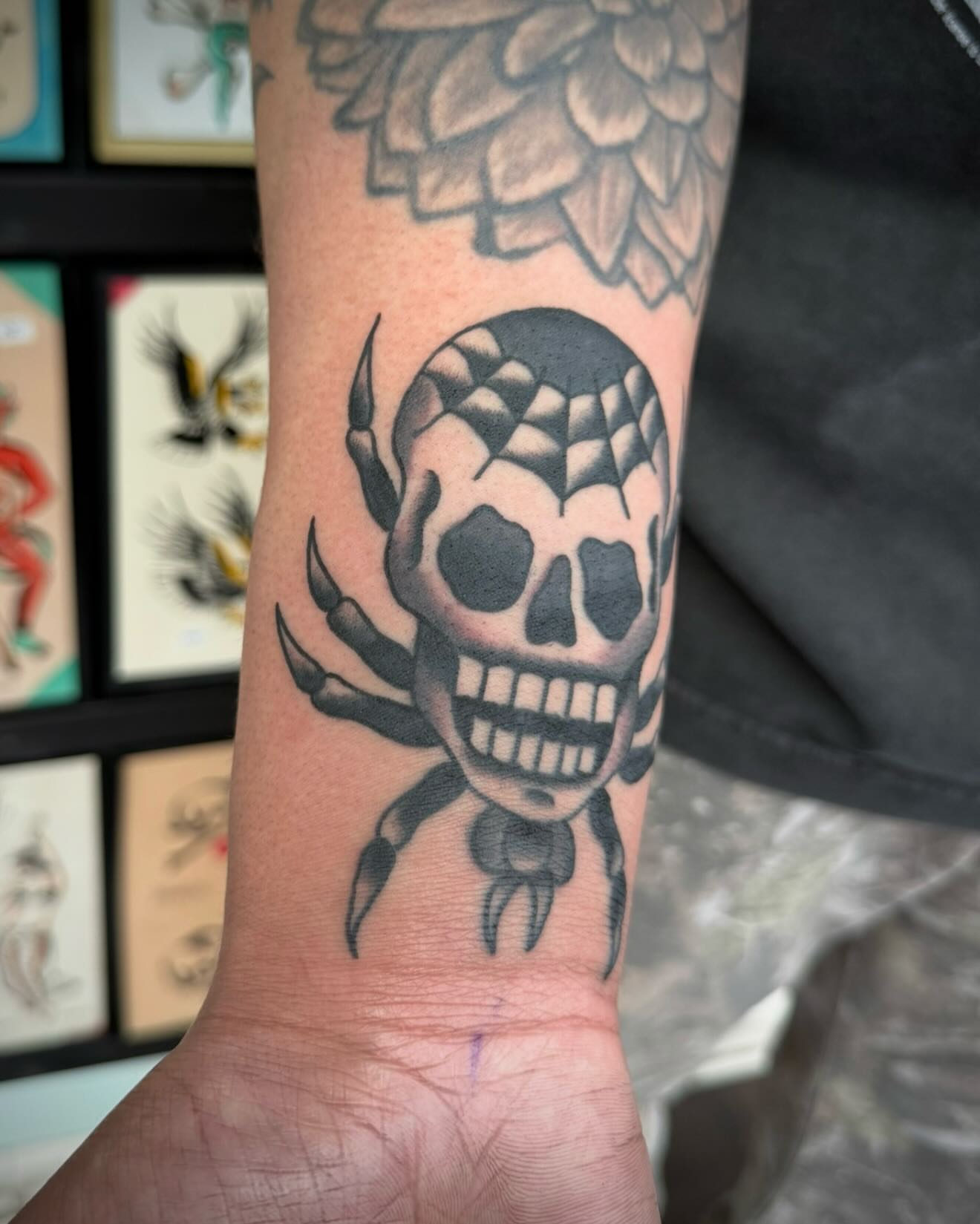 Skull with spider American traditional tattoo on the forearm by kalli berry