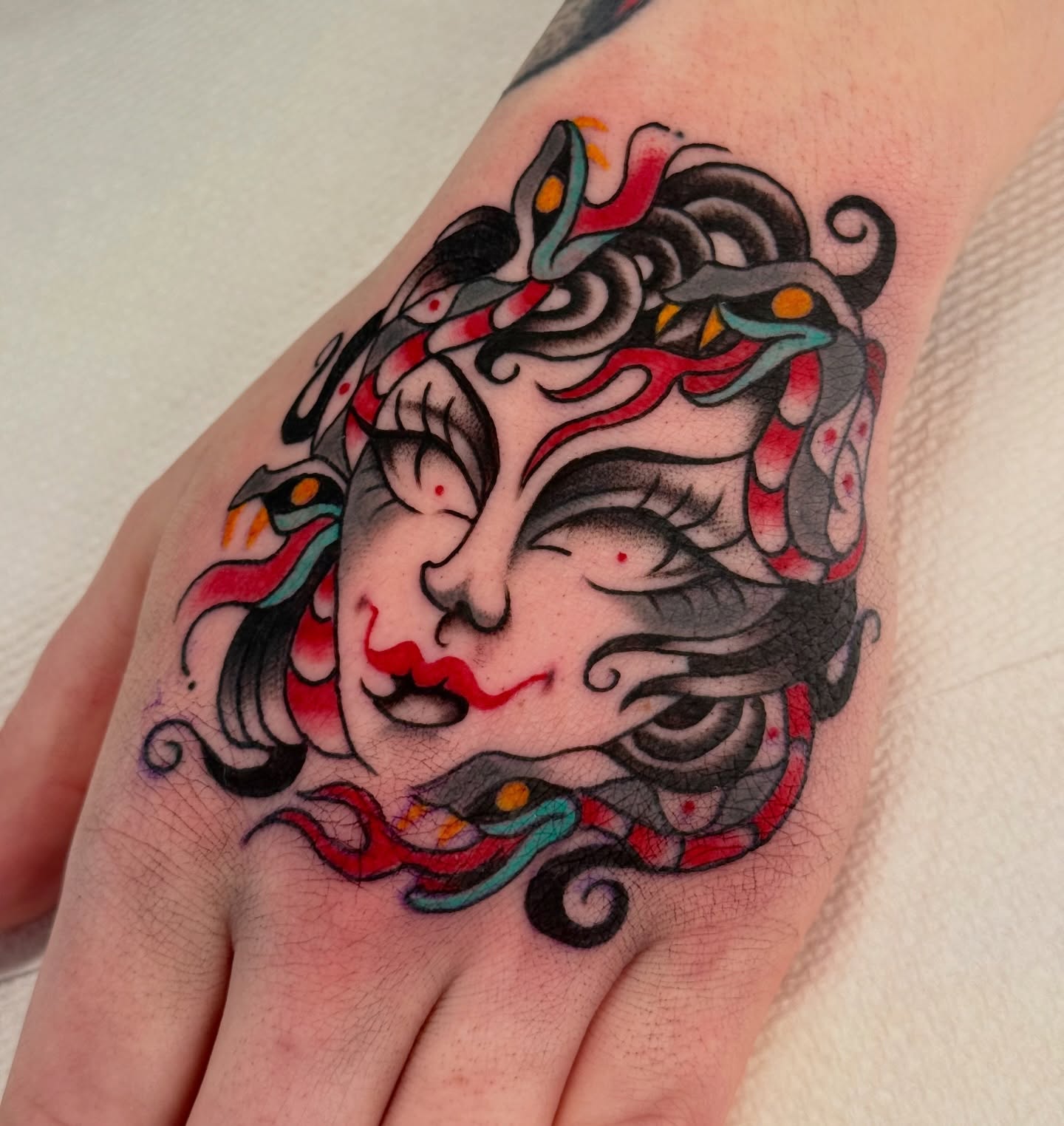 Woman's face American traditional tattoo on the hand by sydtatz