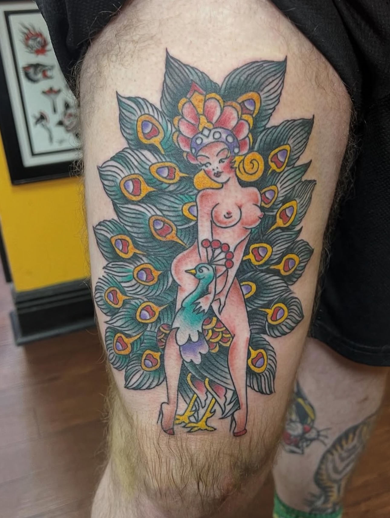 Peacock and woman American traditional tattoo on the thigh by Keith Underwood
